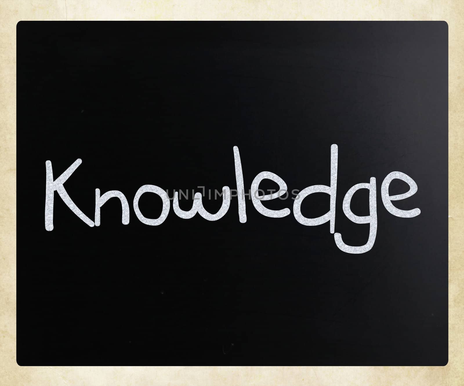 "Knowledge" handwritten with white chalk on a blackboard