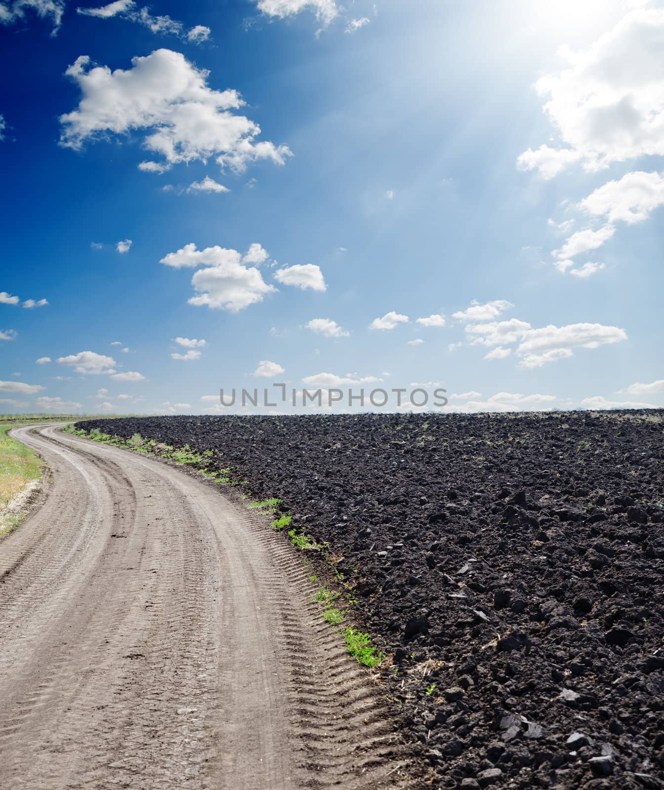 rural road near black ploughed field