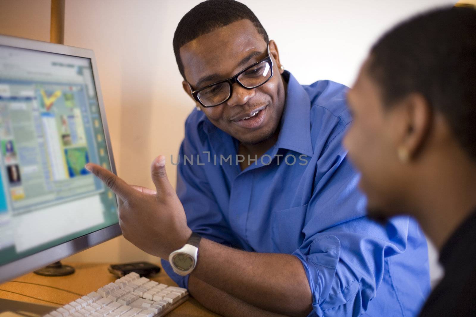 Instructor discussing work at a computer monitor
