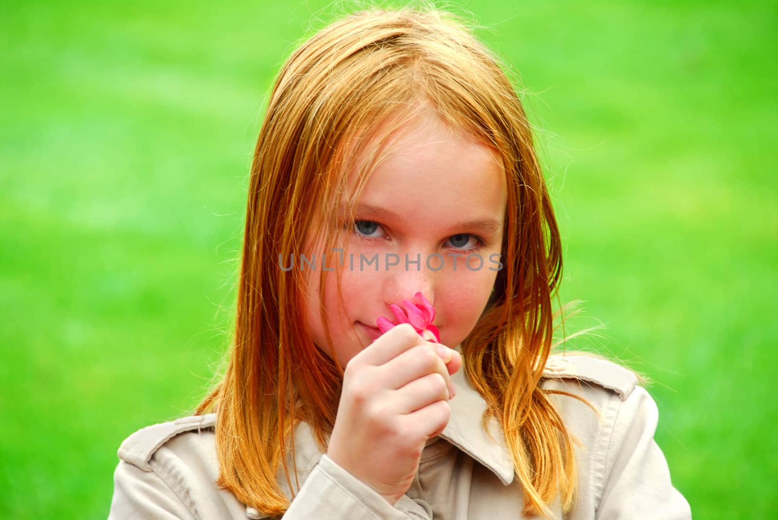 Young girl holding a pink flower in her hand