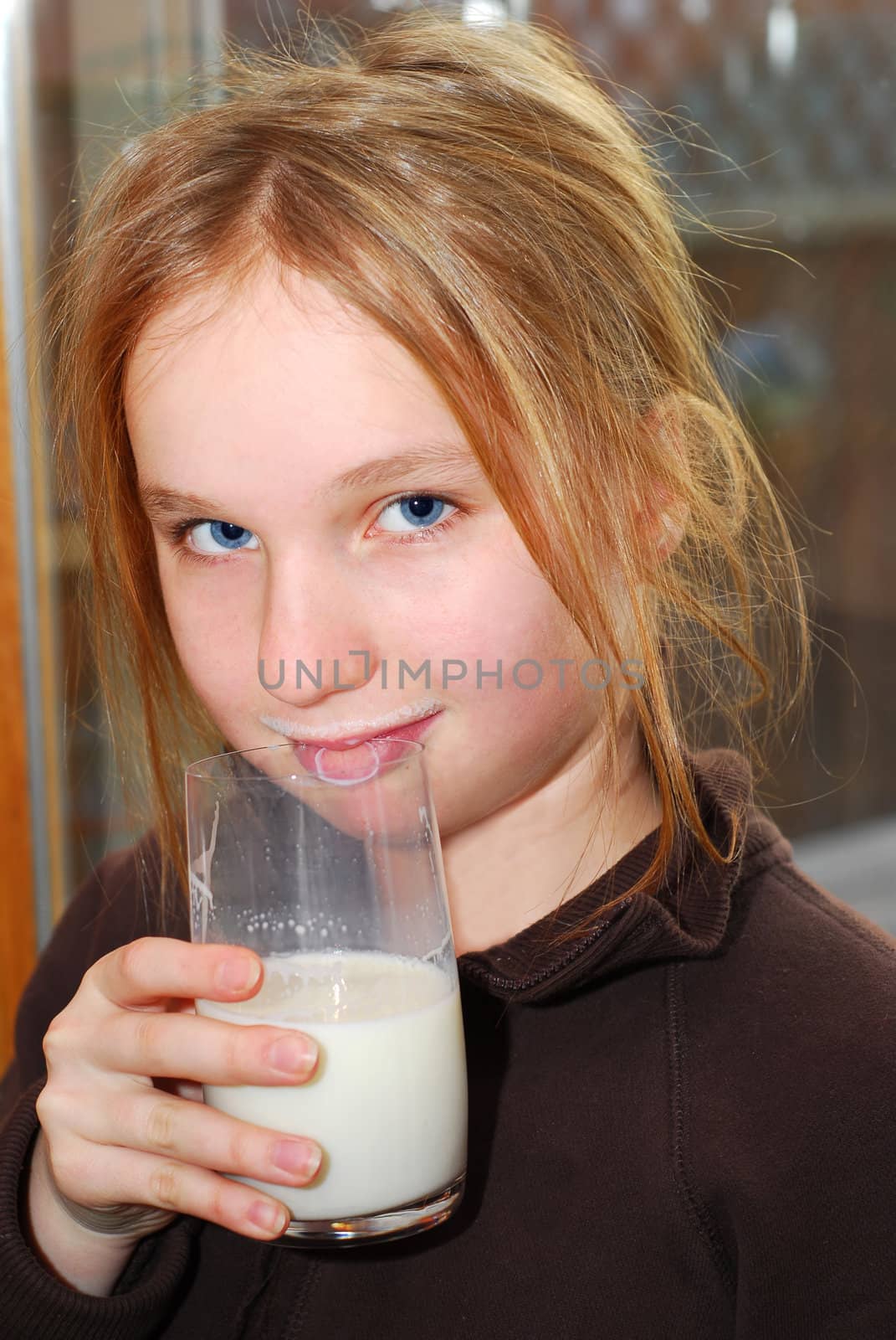 Young girl holding a glass of milk in the morning