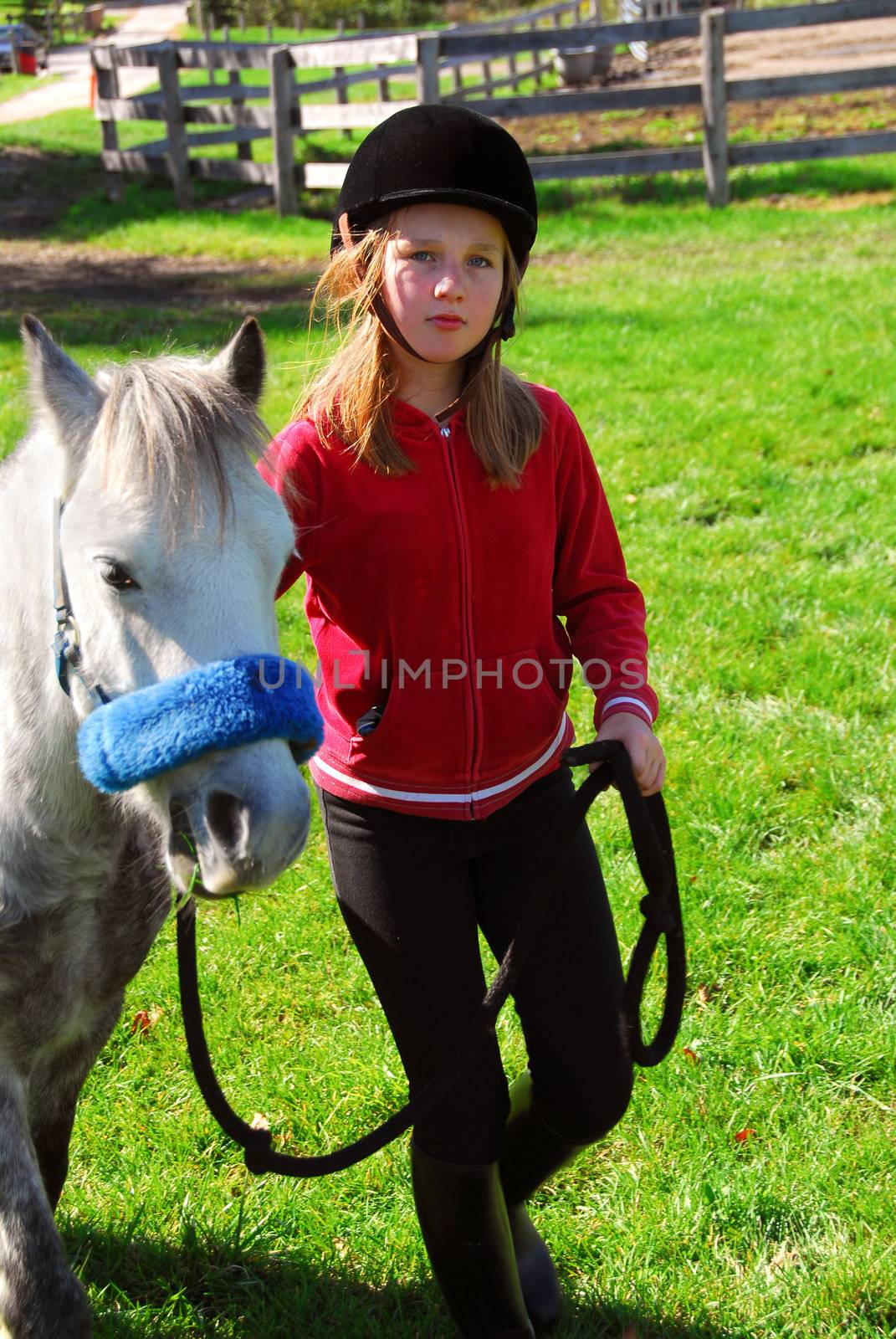 Young girl leading her pony out to pasture