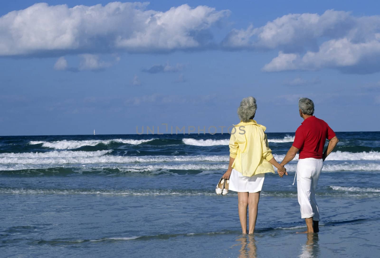 Senior couple holding hands on the beach