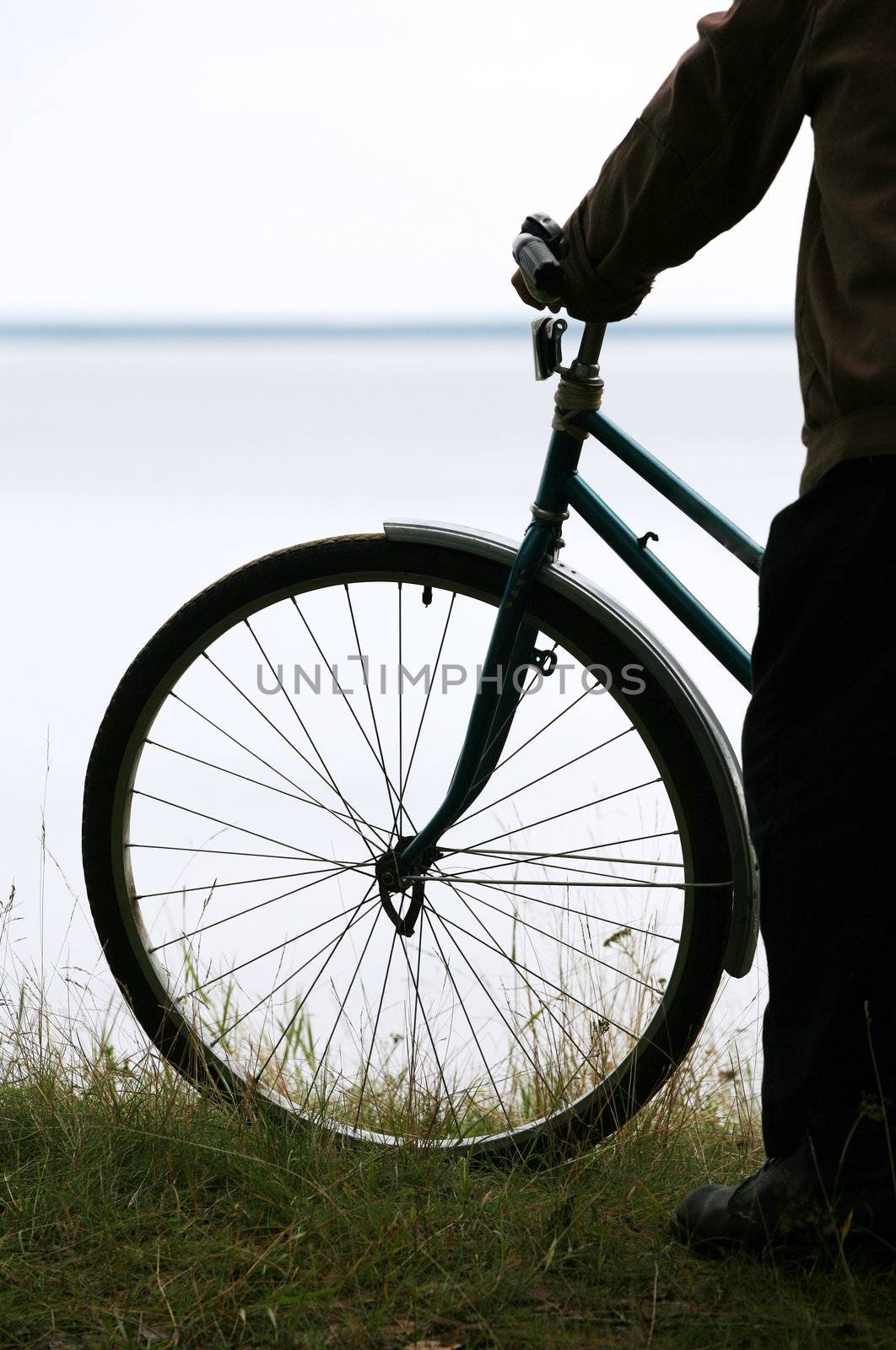 Silhouette of the bicyclist on a coast of the river