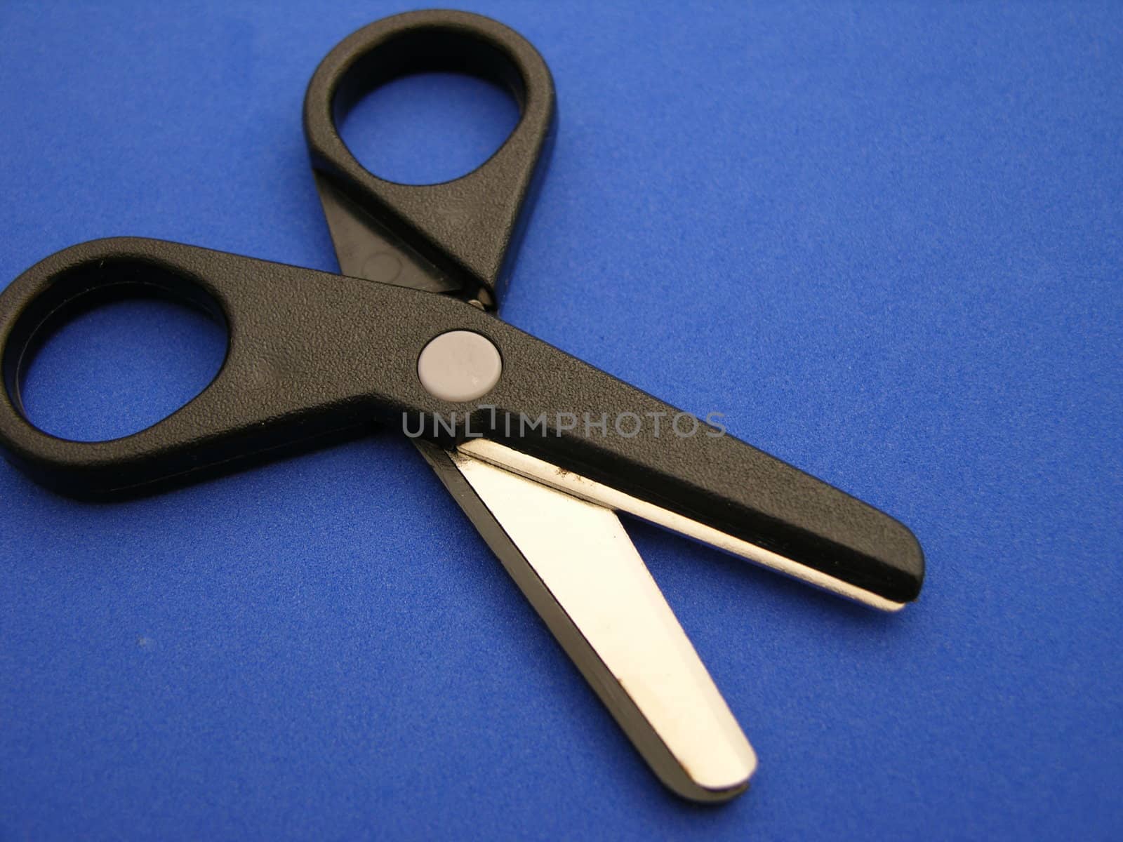 A closeup view of paper scissors on a blue background