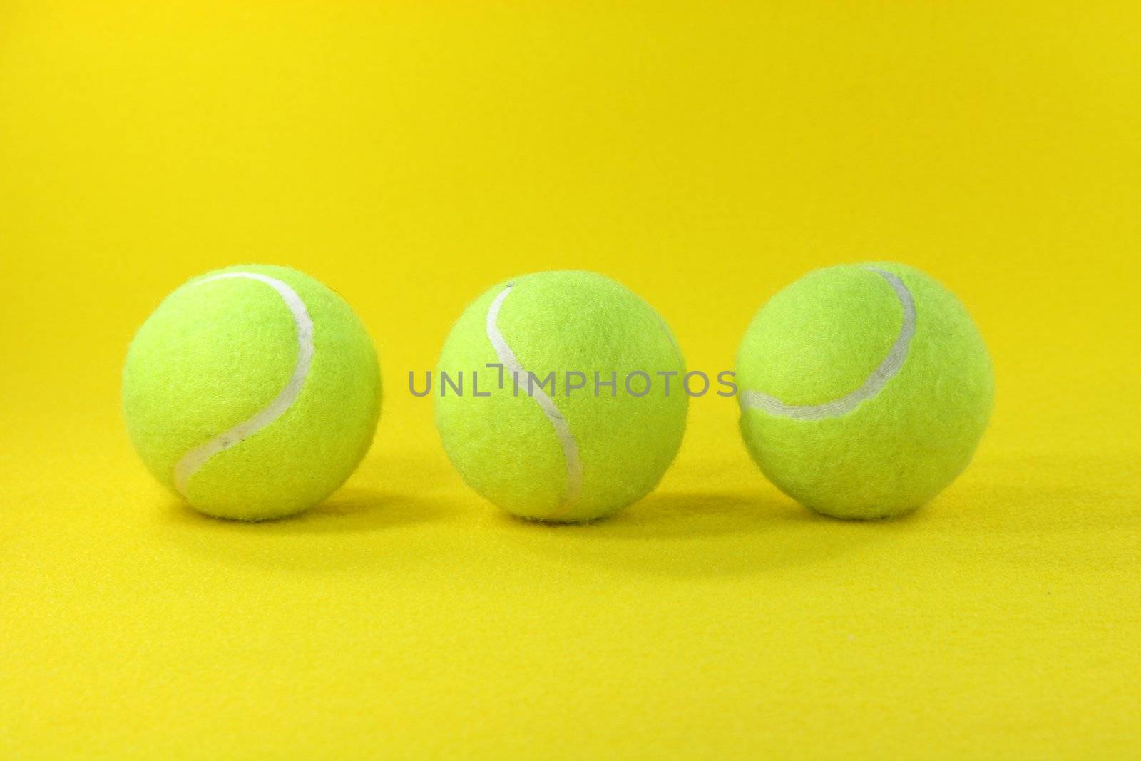 three yellow tennis balls center with yellow background sports concepts