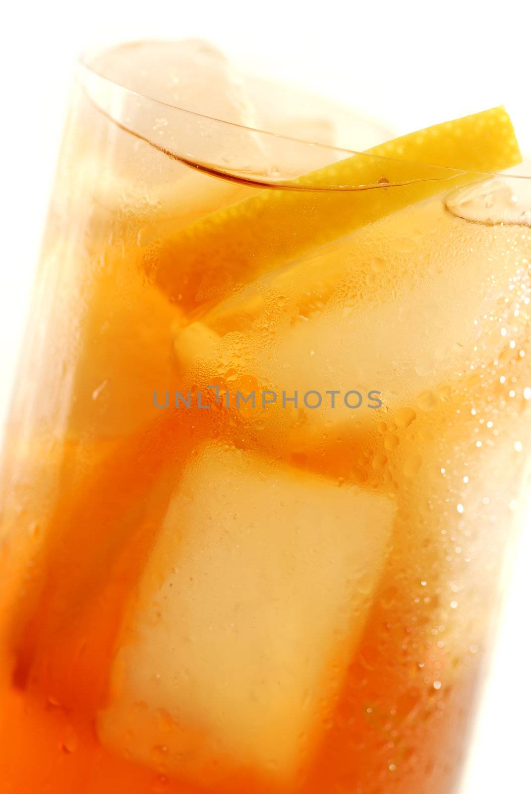 Glass of cold lemon iced tea with ice and lemon, water drops on surface