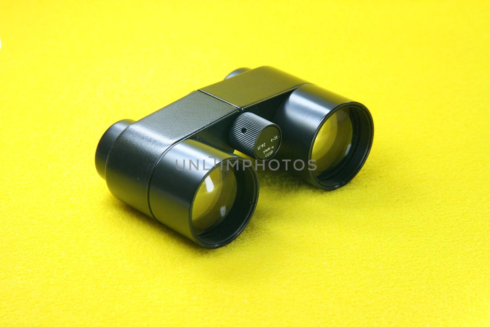 black retro binoculars from ussr in yellow background optic tools