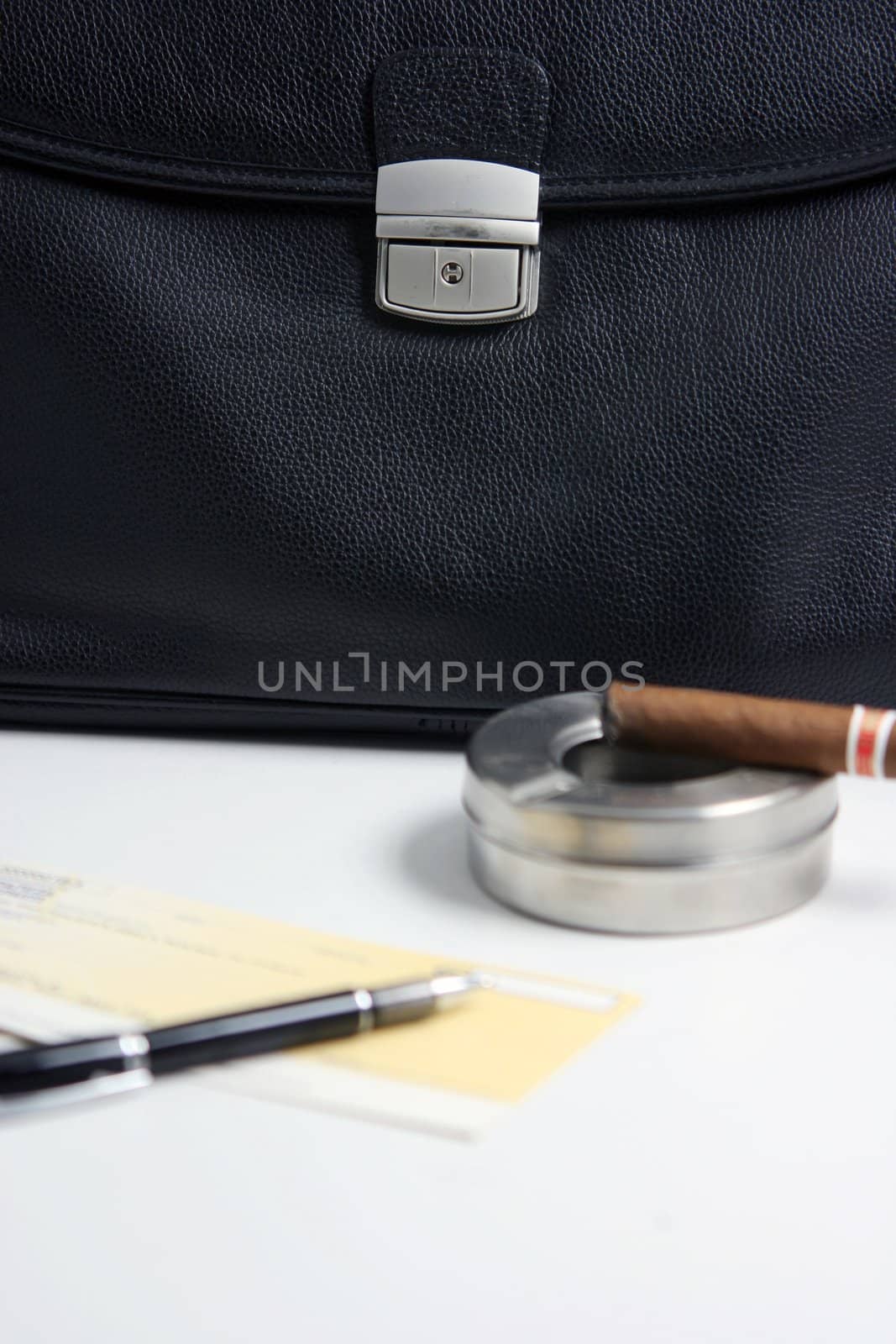 focus on the black leather financial deal check writing cigar with black leather briefcase background praspective business concepts