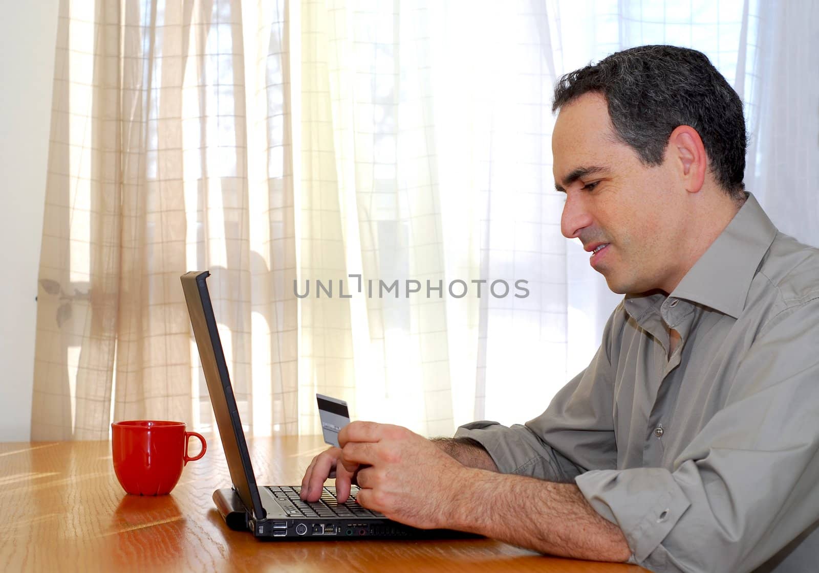 Man sitting at a desk with credit card shopping online