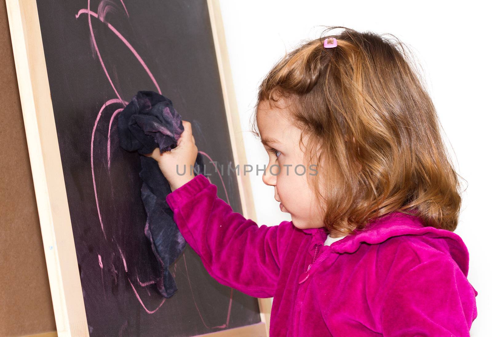 Little girl writing on a blackboard
