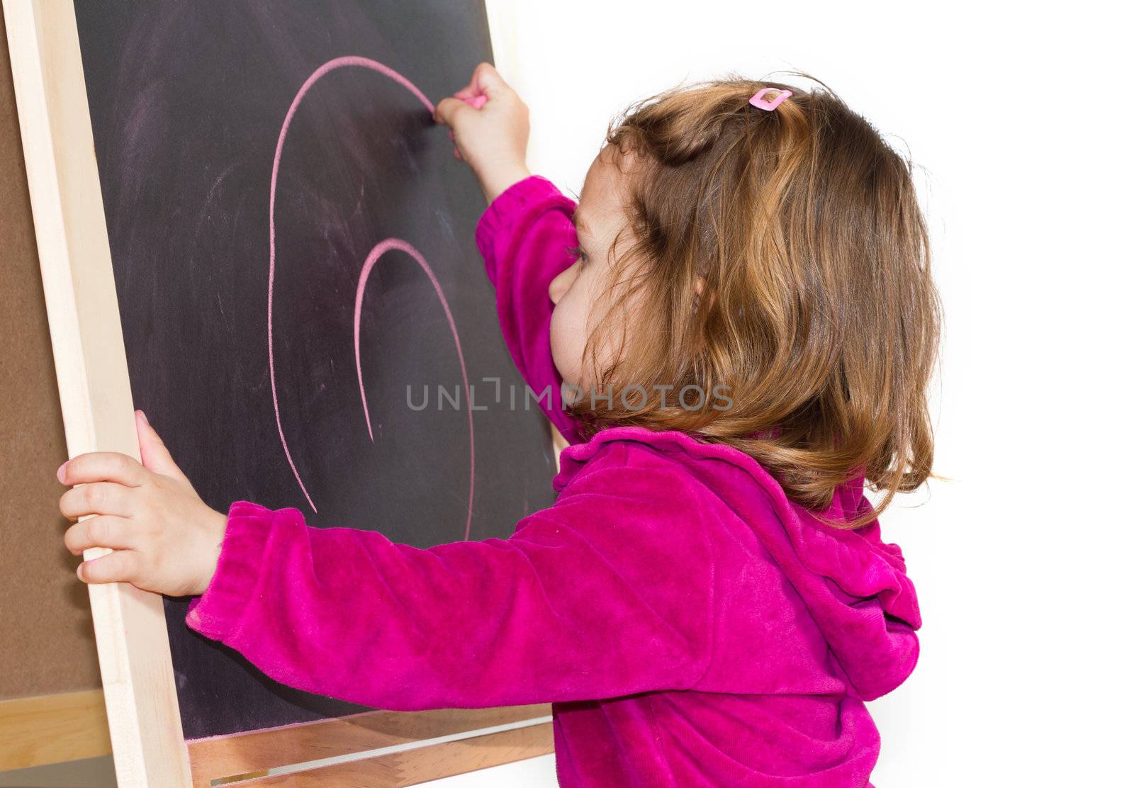 Little girl writing on a blackboard