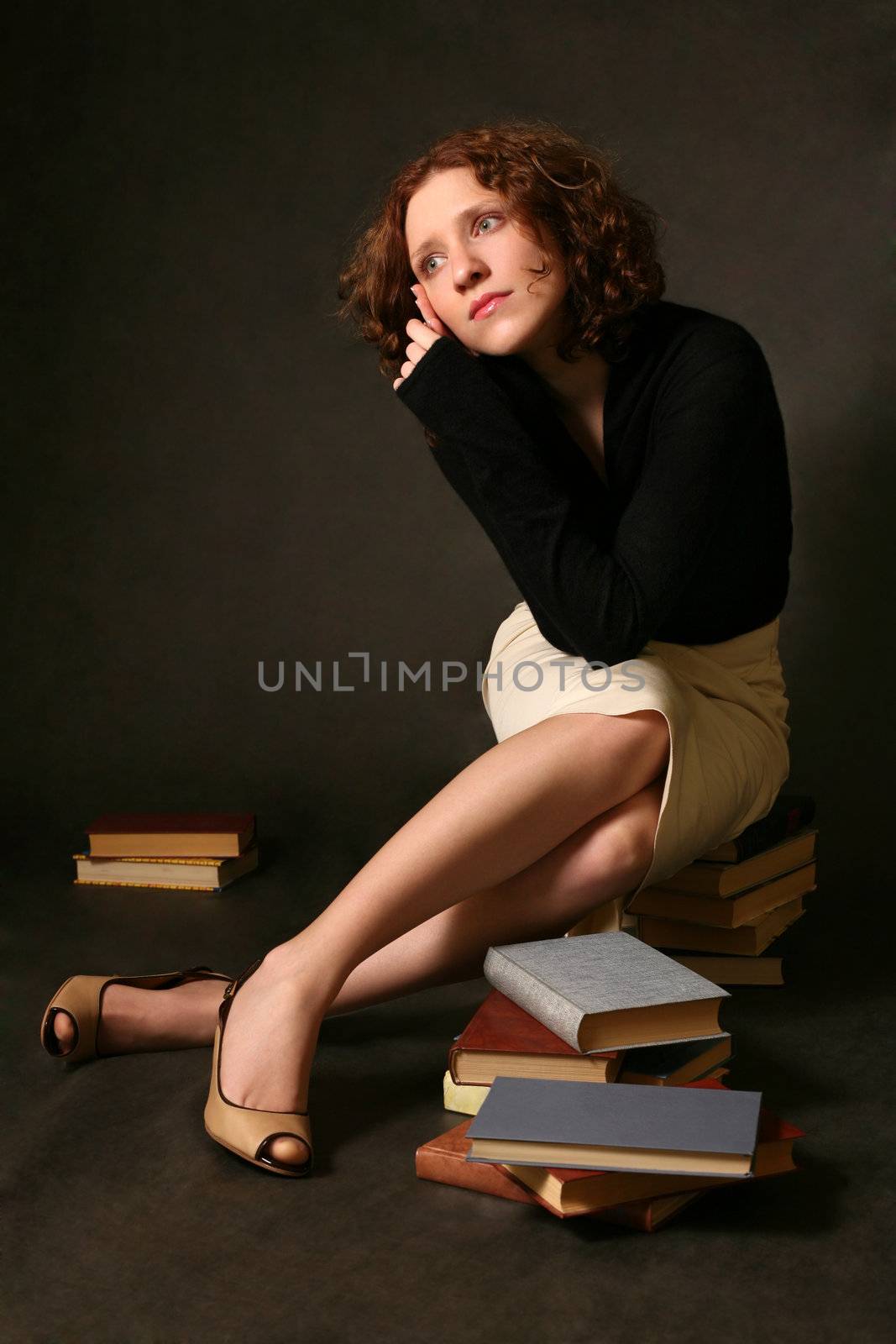 The thoughtful red-haired girl with books