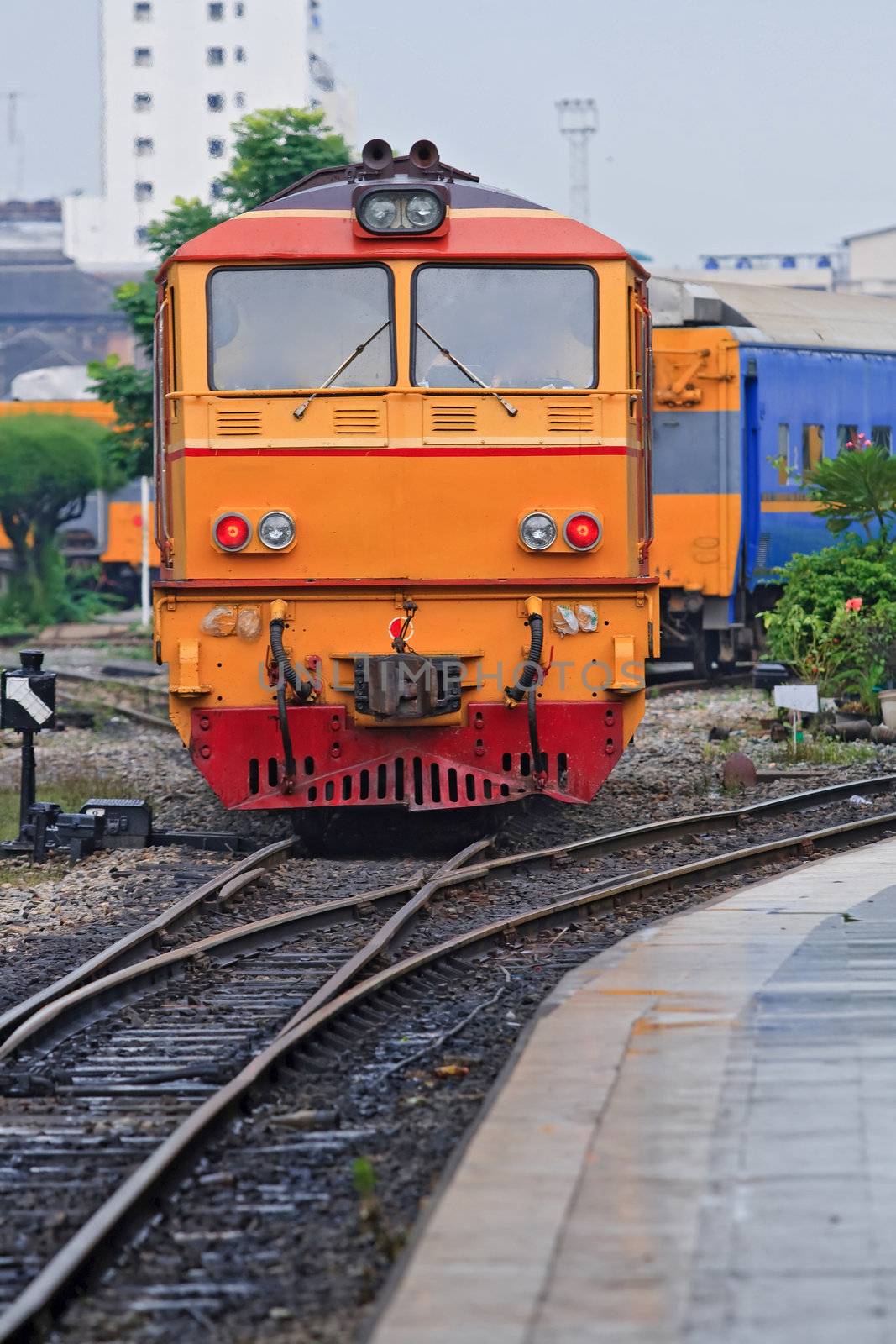 Closeup of Red Yellow Diesel Engine Train locomotive approaching to Bangkok Railway Station Thailand, Vertical
