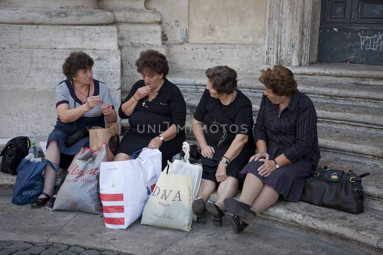 RESTING THE LEGS, ROME, Italy - SEPTEMBER 26, 2011: Senior ladies resting while waiting for the bus after heavy shopping in city.