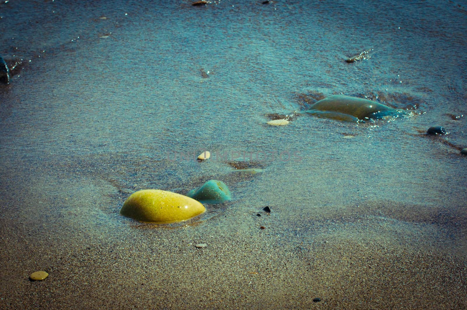 Stones on wet sand on an ocean coast