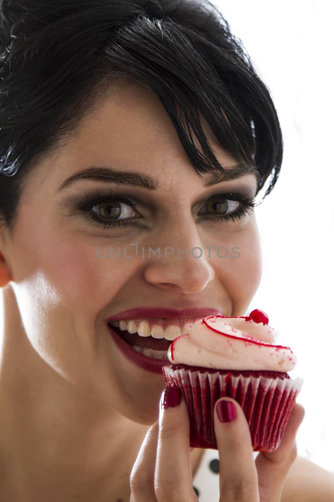 young woman bitting in a velvet cupcake