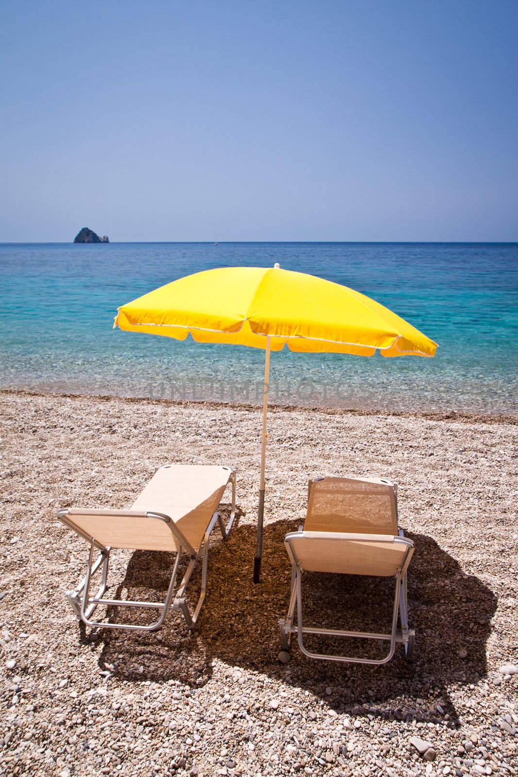 Parasol and sun loungers on the beach