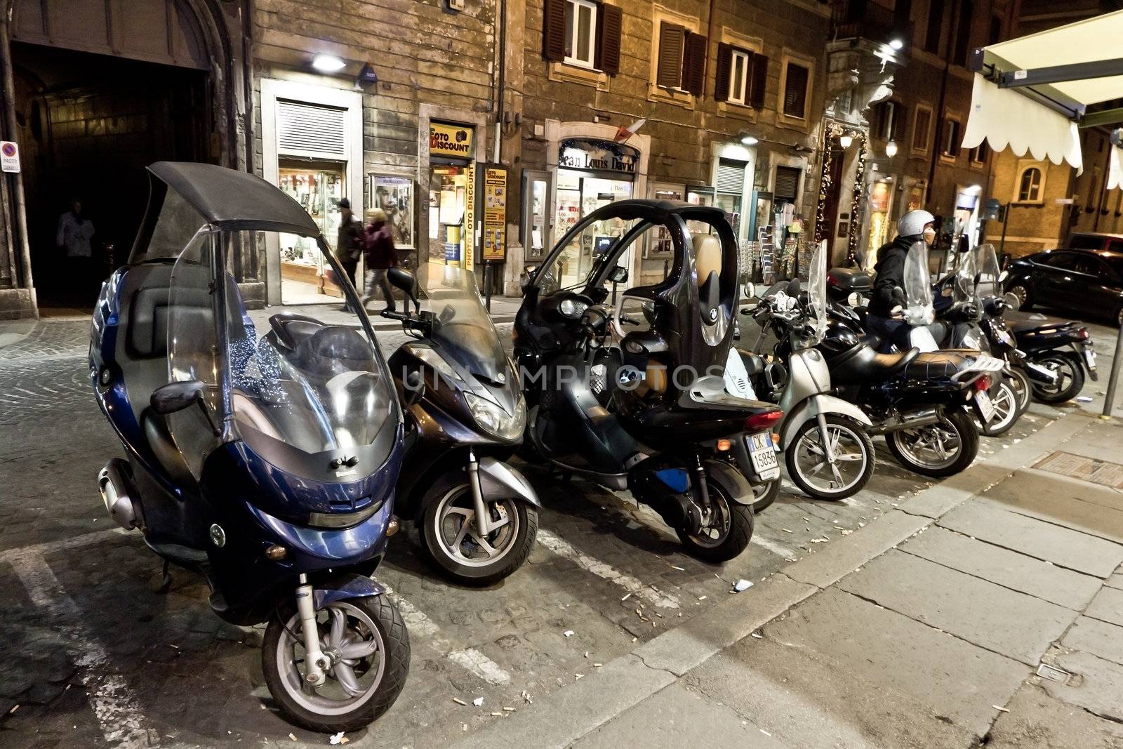 Many motorbikes parked in an alley in Rome, Italy