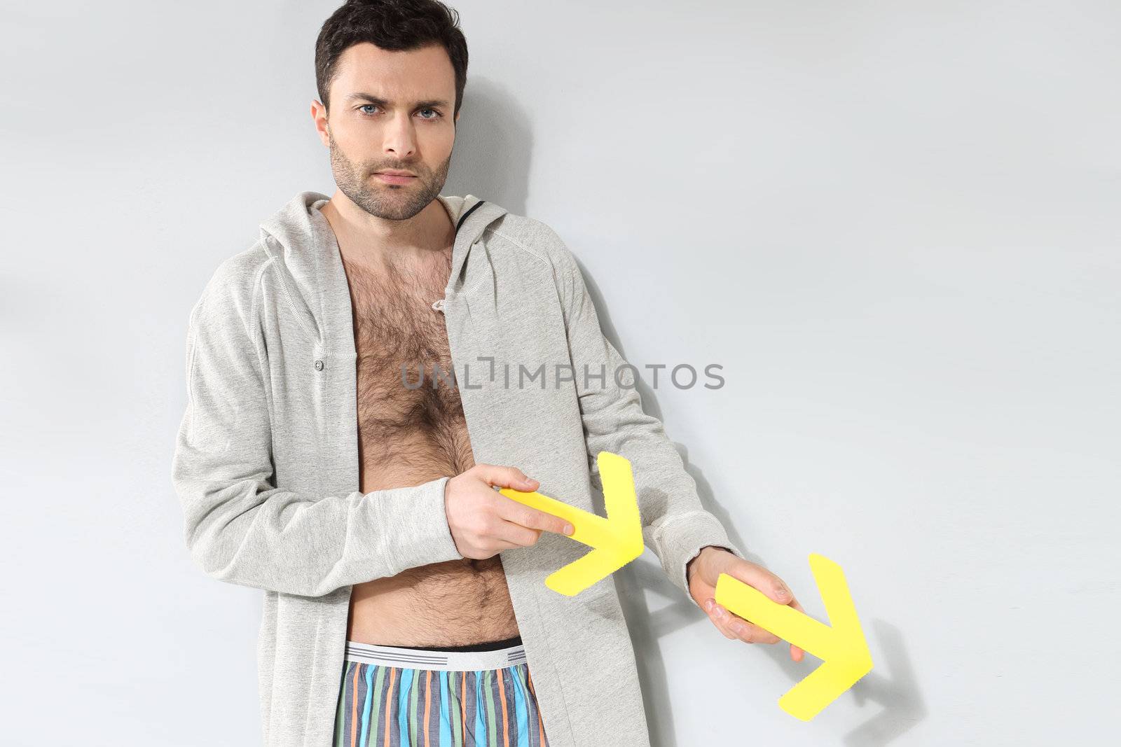 Man holding yellow arrows on a gray background