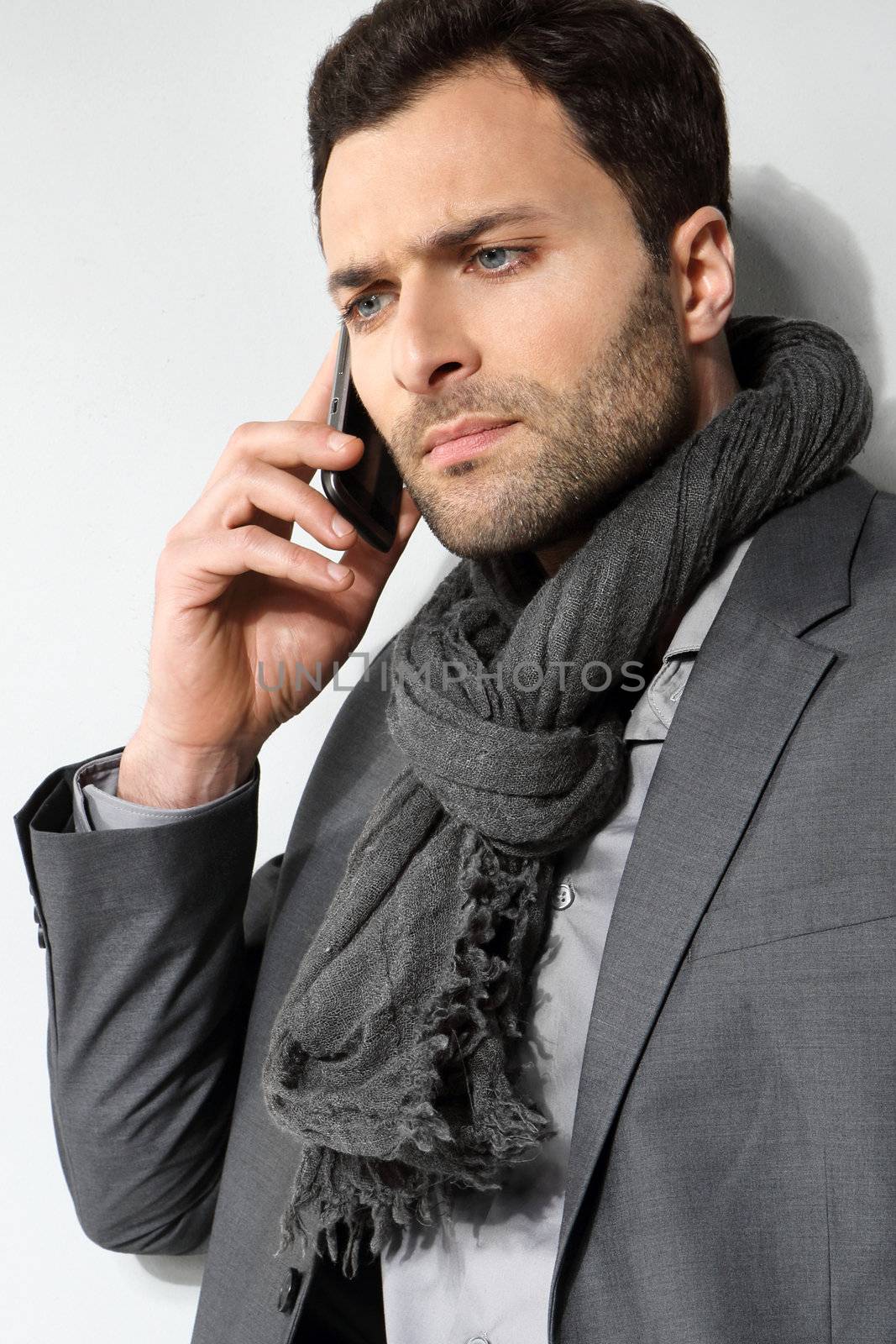 Young businessman using cell phone, over grey background by robert_przybysz