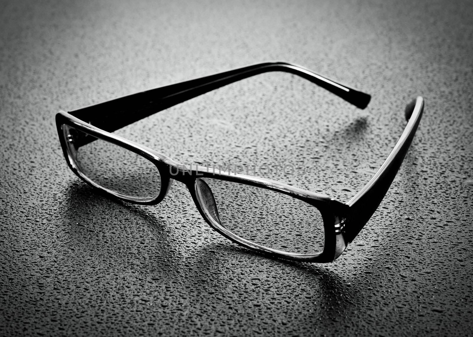 Reading glasses on dark wood