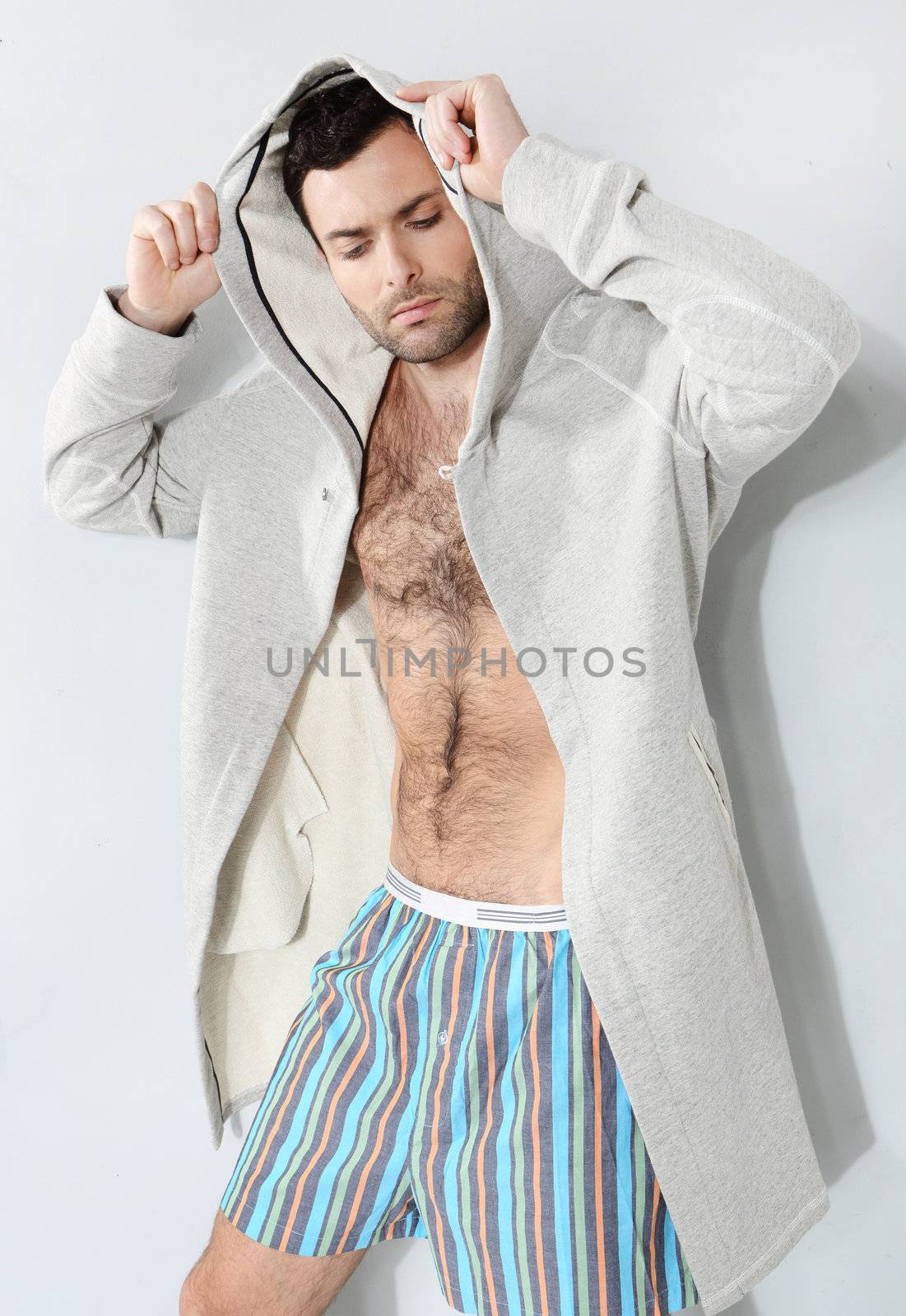 Stylish man in shorts on a gray background