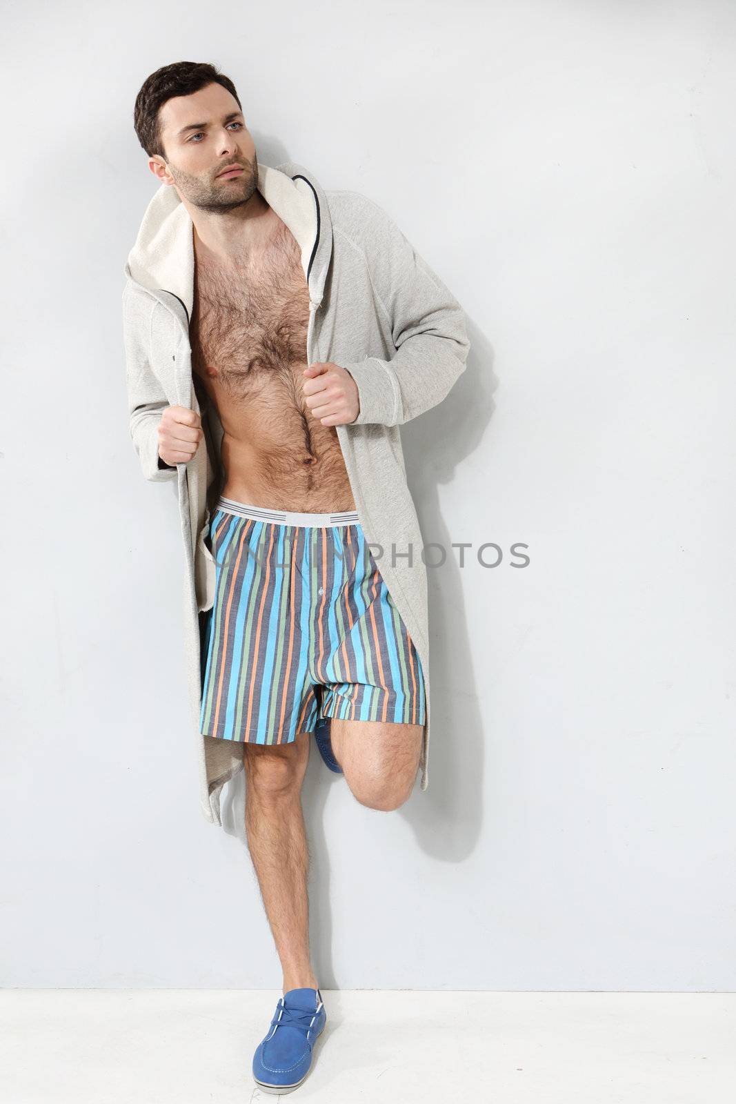 Stylish man in shorts on a gray background