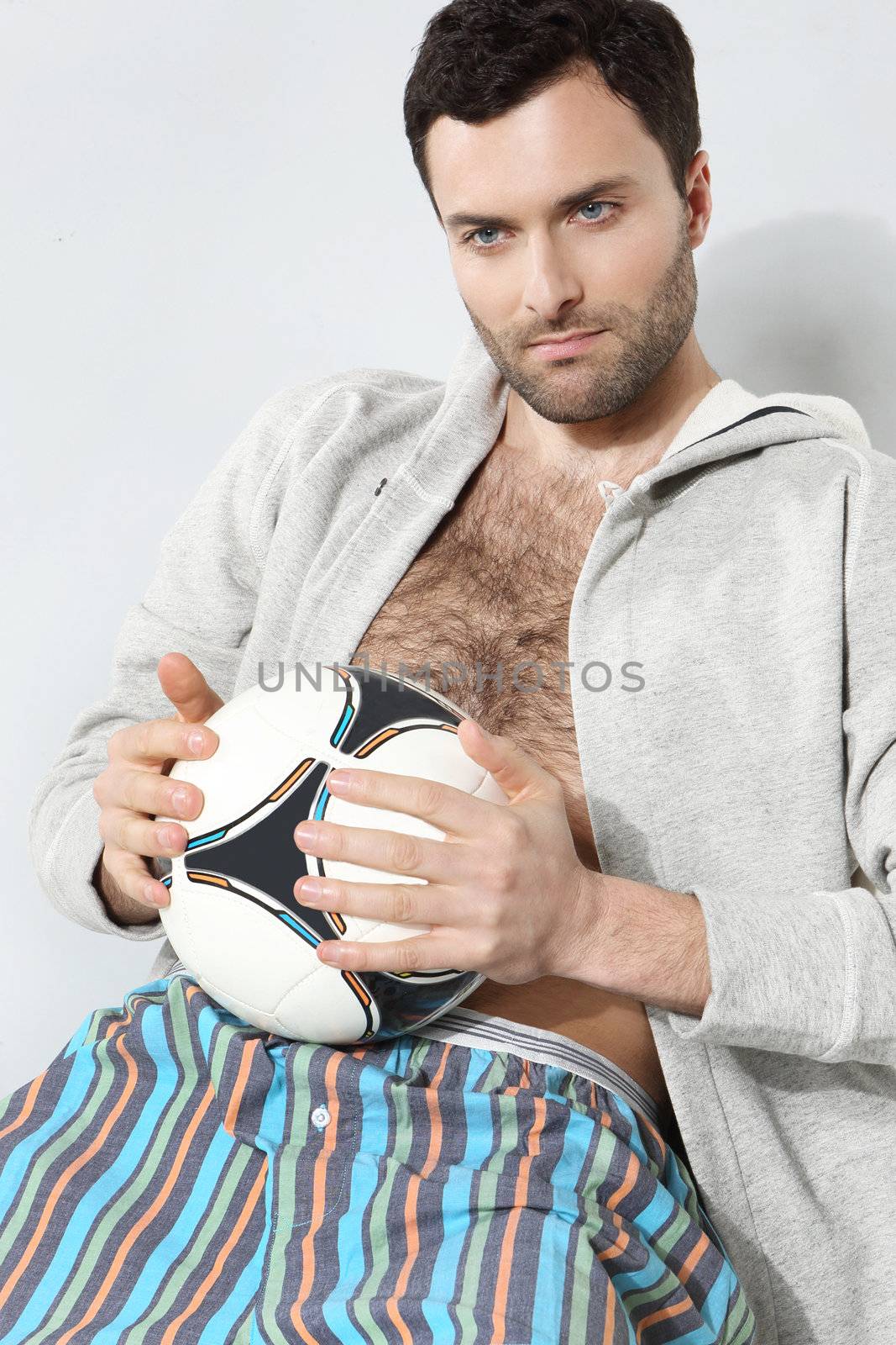 Man with a soccer ball on a gray background