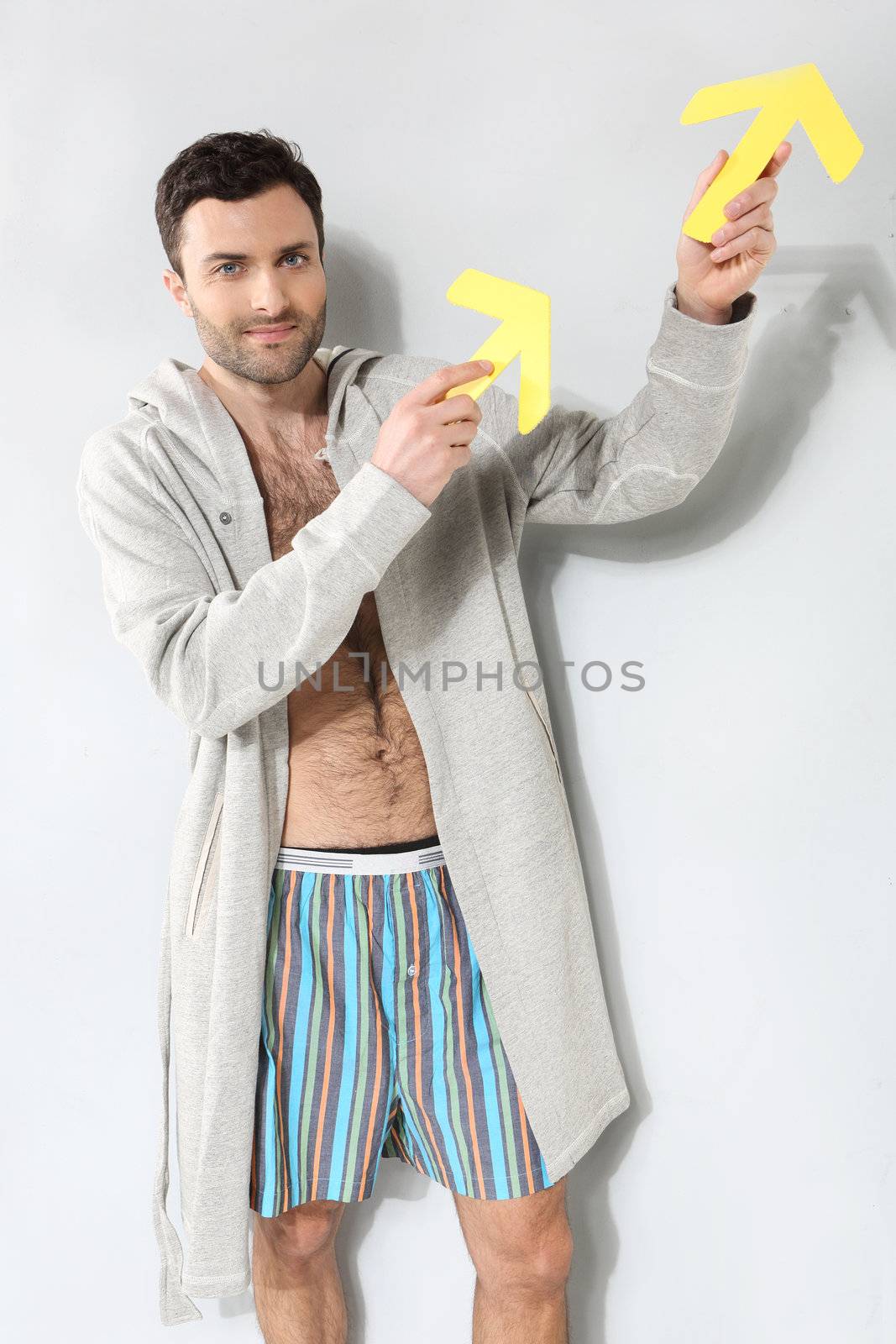 Man holding yellow arrows on a gray background