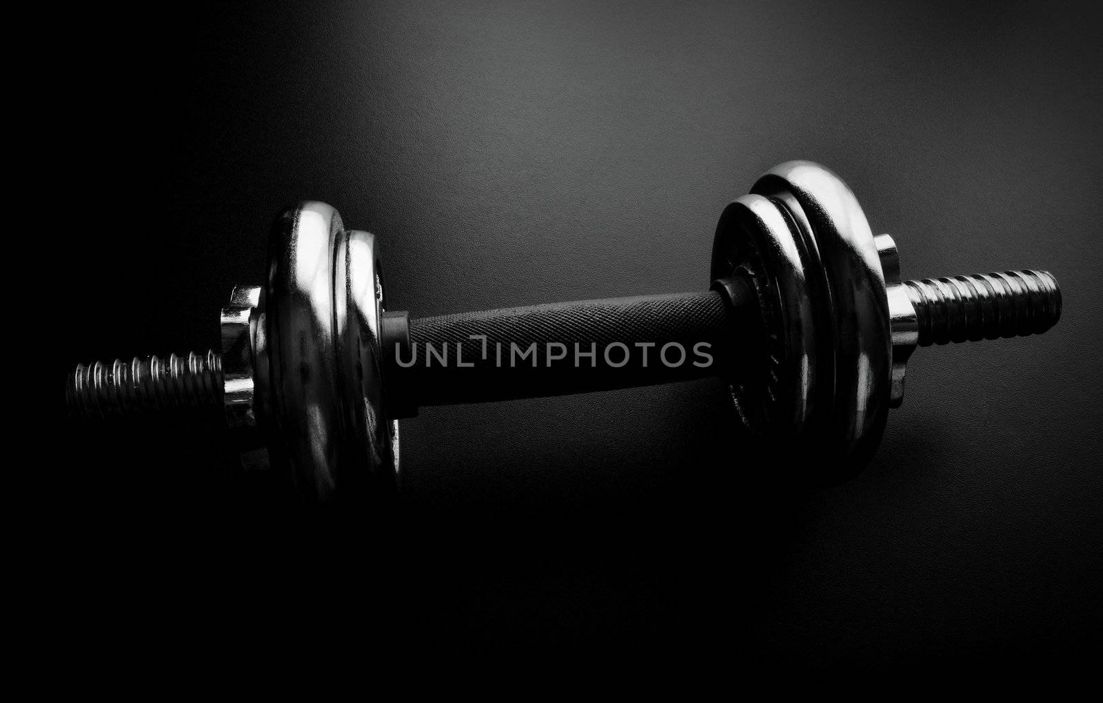 Close-up of an chrome dumbbell on dark background