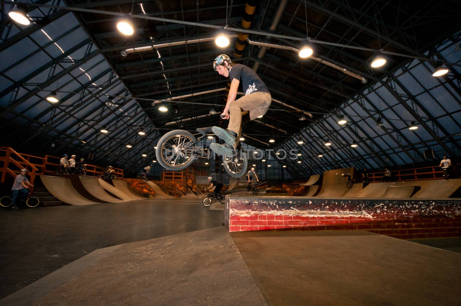 Biker doing tail whip trick in wooden park