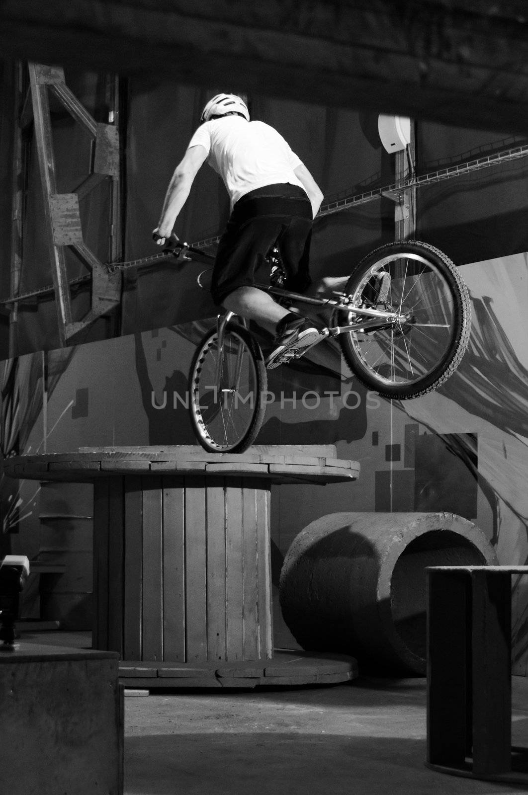 Cyclist standing on big coil on front wheel by dmitryelagin