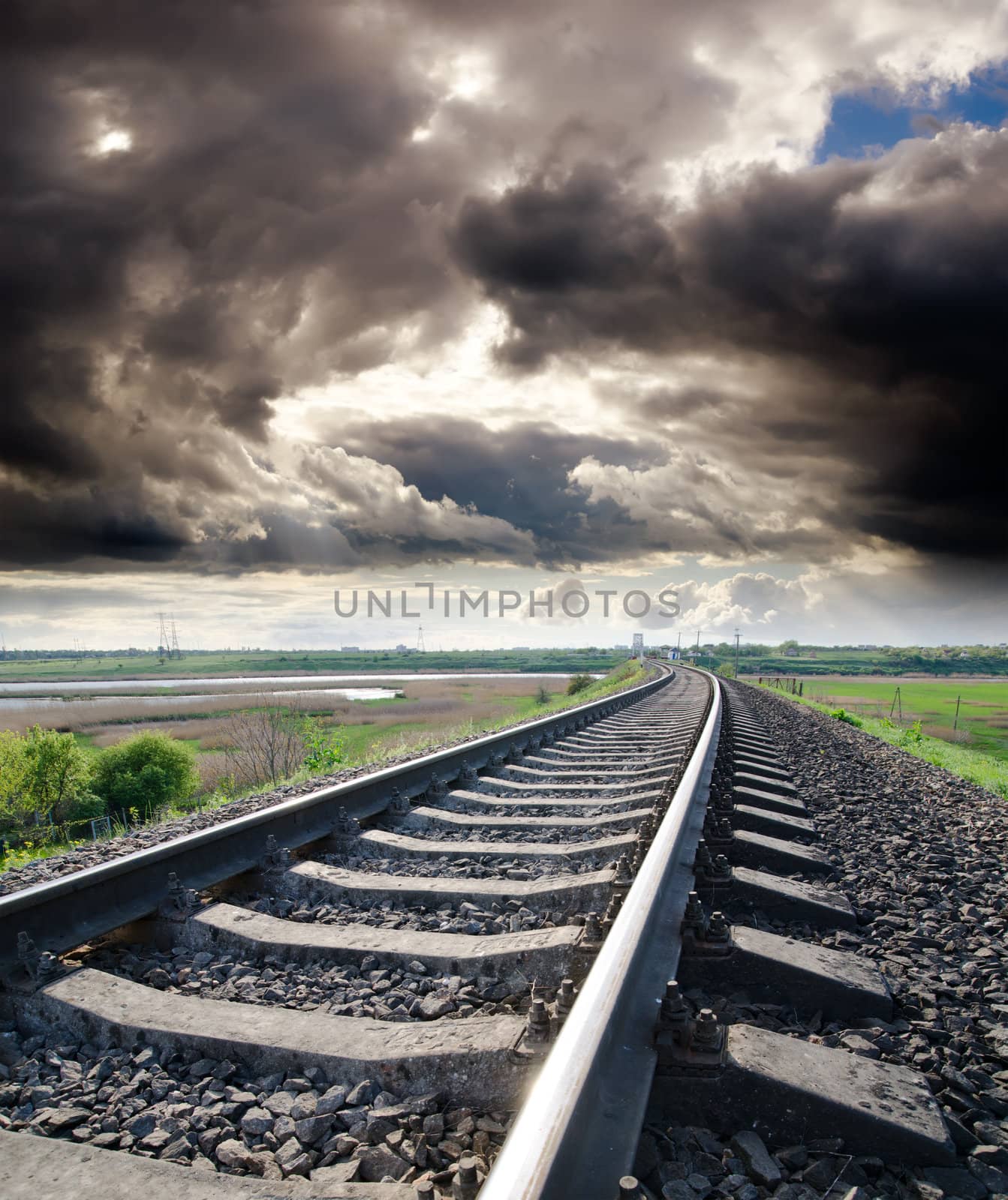 view to railroad goes to horizon under cloudy sky with sun by mycola