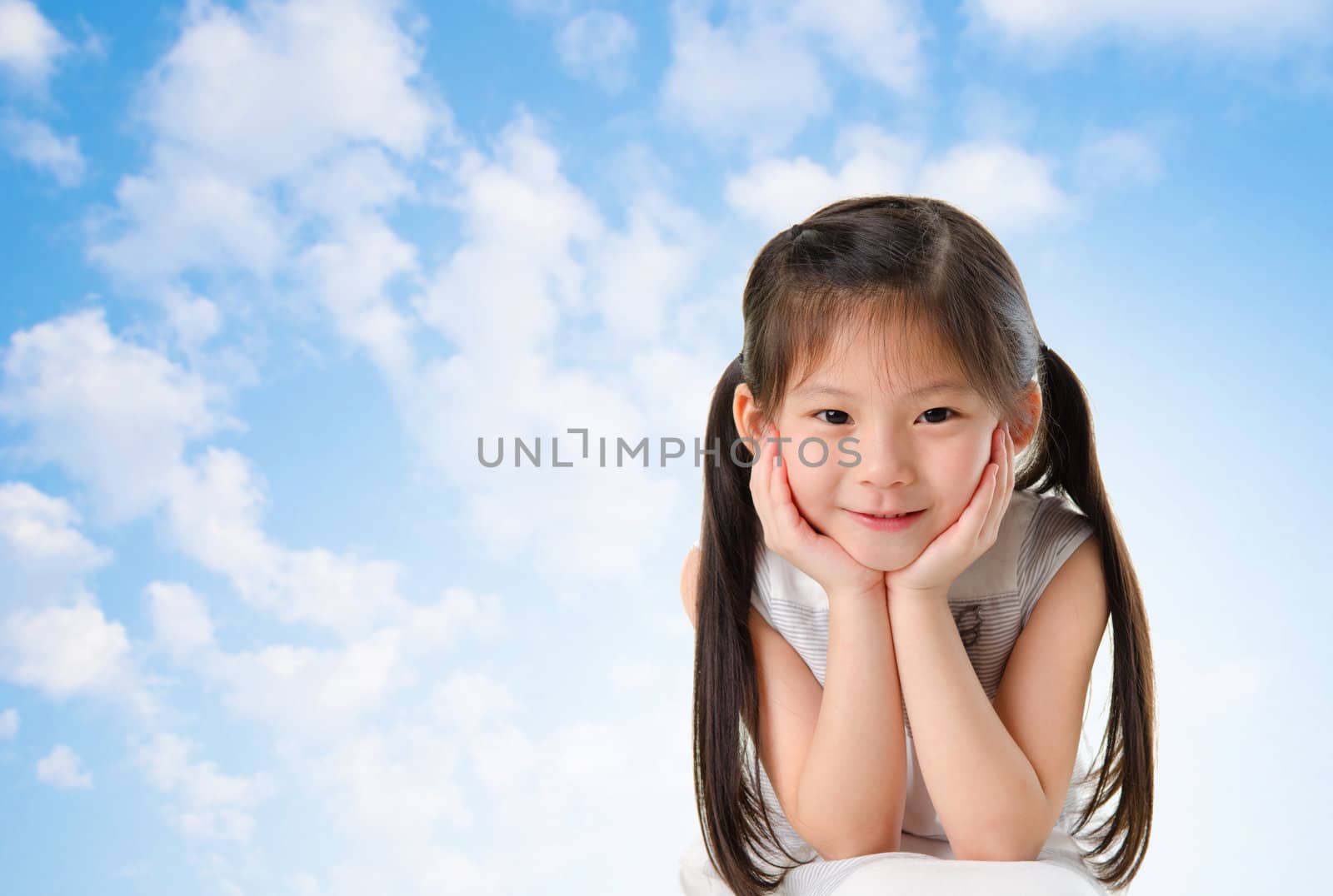 Young Asian girl with smile on her face sitting outdoor in summer day, blue sky background