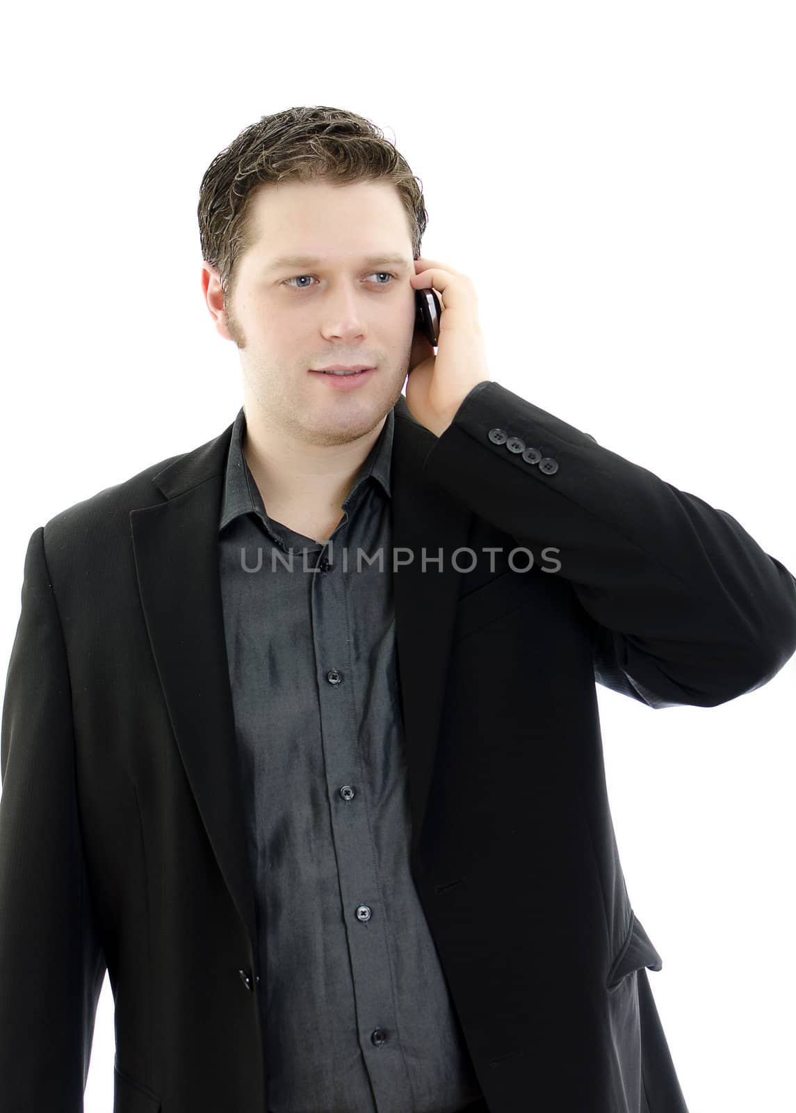 Portrait of a handsome young business man talking on mobile phone. Isolated on white background with copy space.