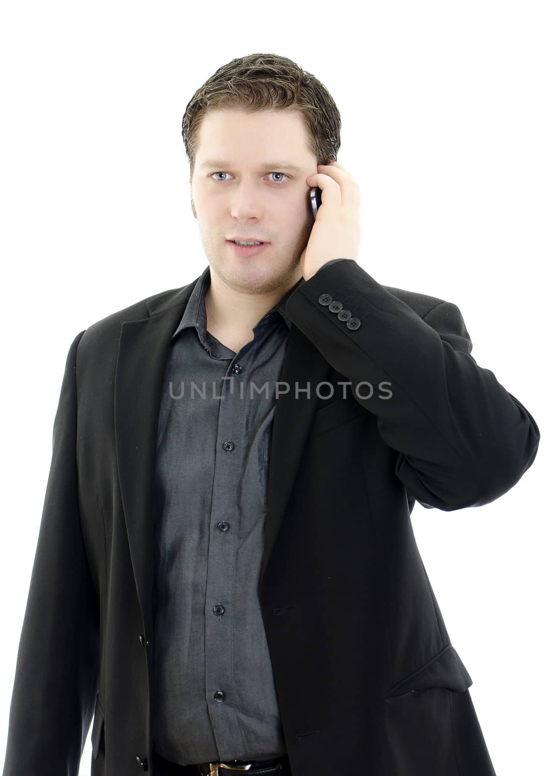 Portrait of a handsome young business man talking on mobile phone. Isolated on white background with copy space.