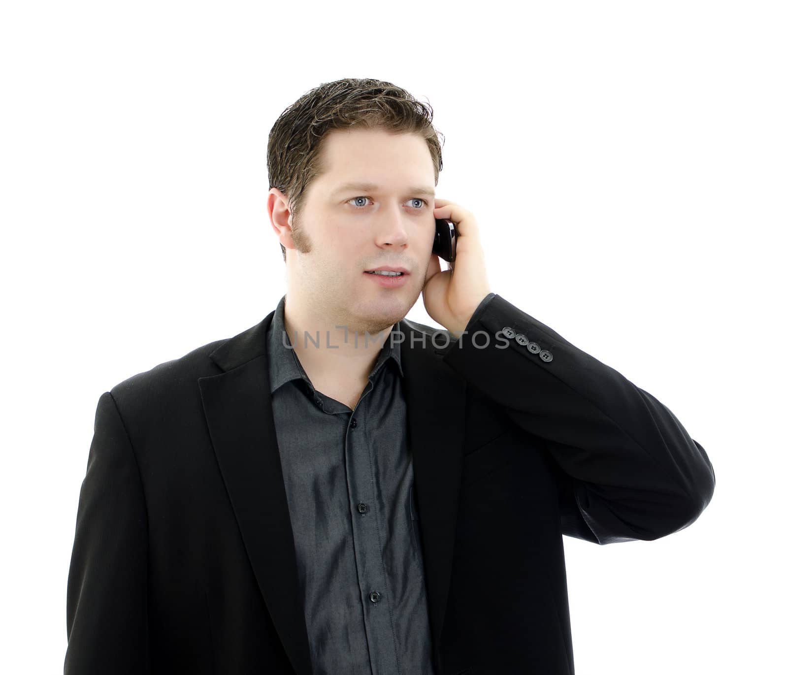 Portrait of a handsome young business man talking on mobile phone. Isolated on white background with copy space.