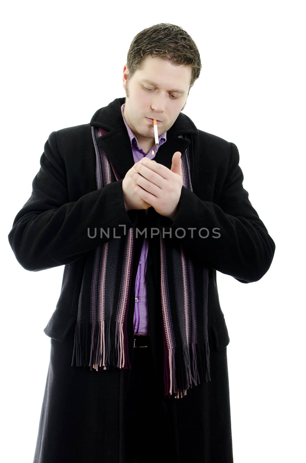 Portrait of a handsome young business man lights a cigarette. Isolated on white background with copy space.