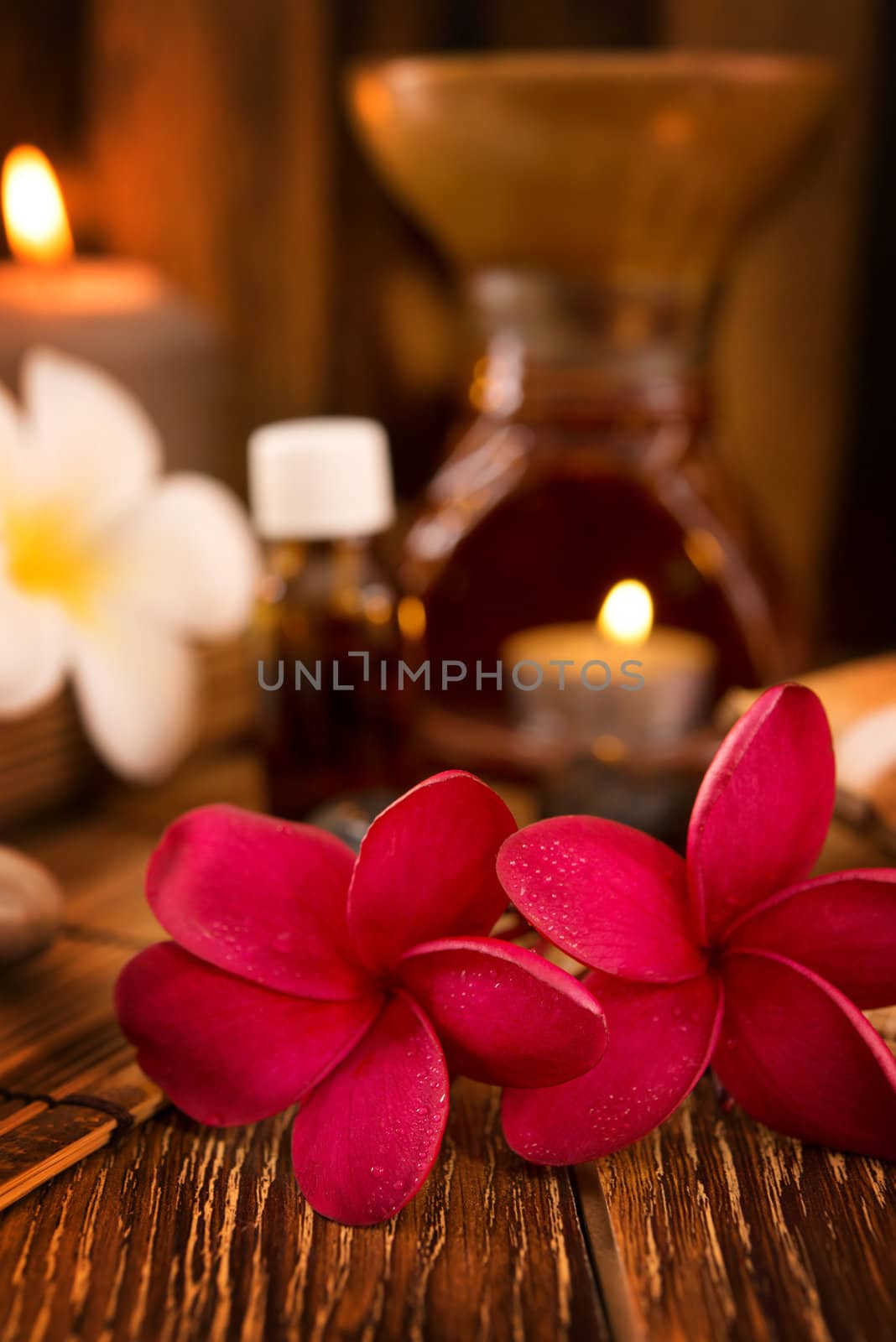 Spa treatment setting with frangipani ,pure essential oil and burning candle.