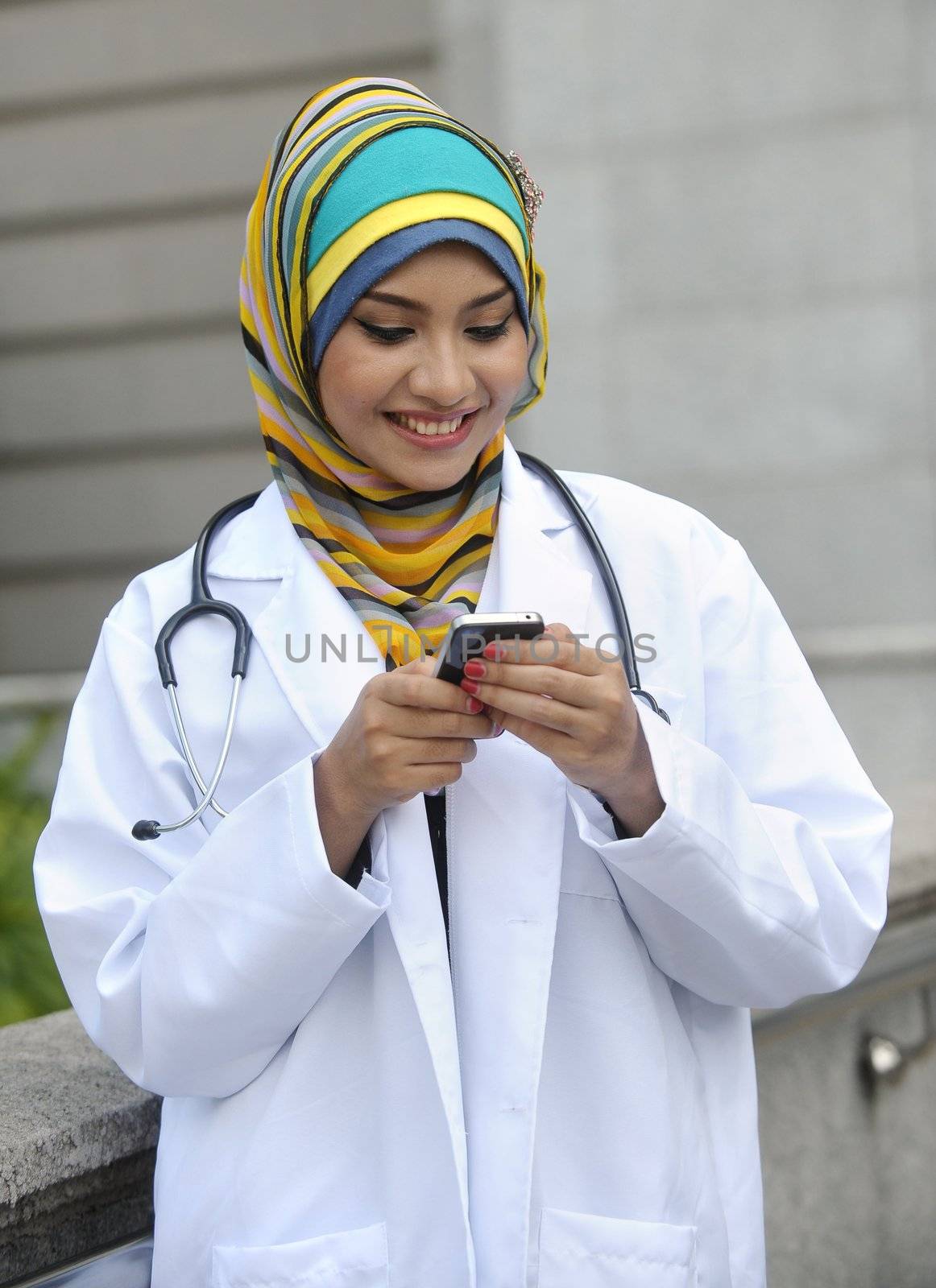 Women Doctor With Scarf use smart phone