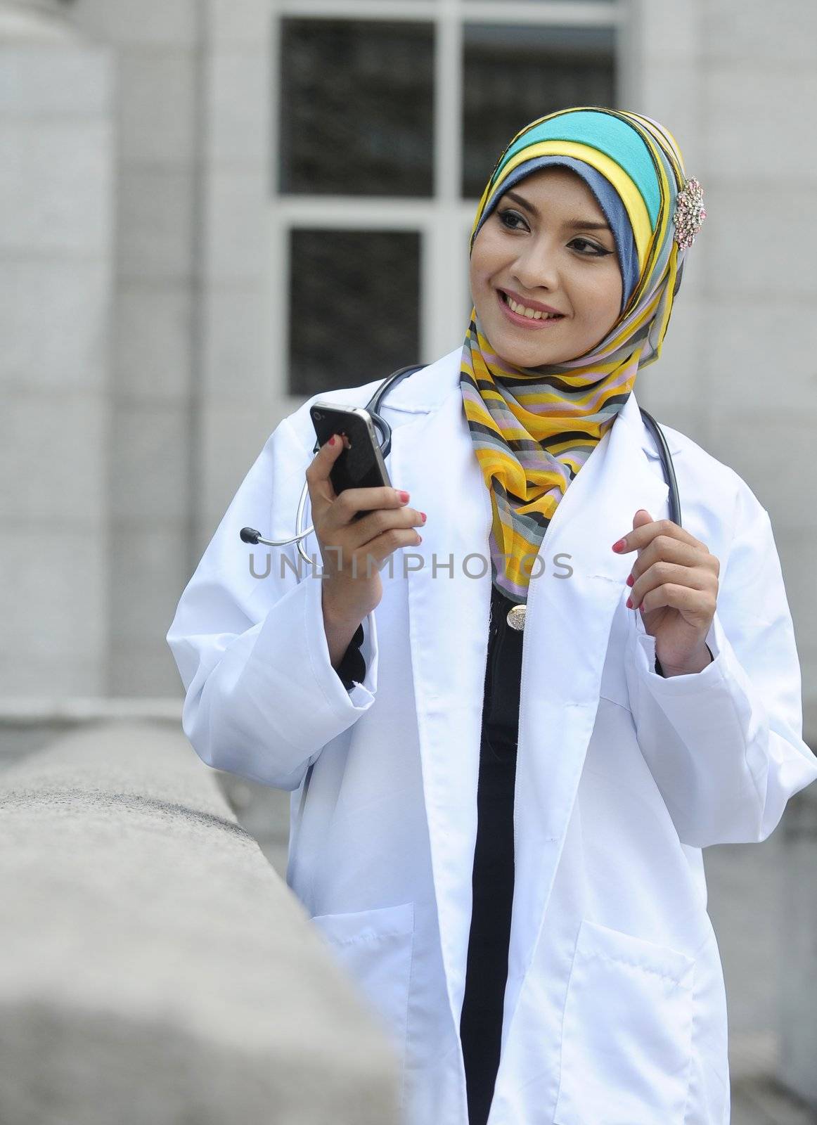 Women Doctor With Scarf use smart phone by jaggat