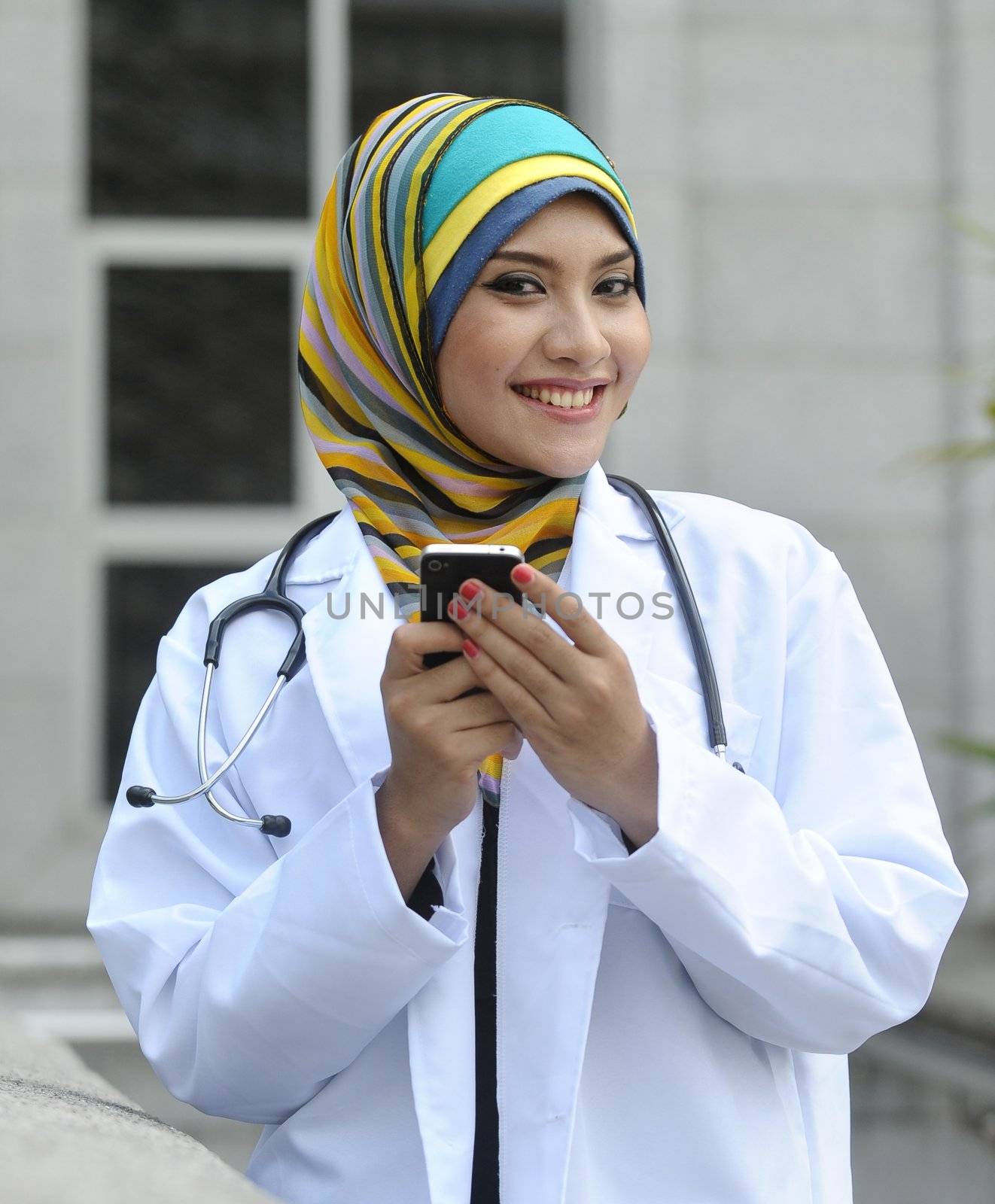 Women Doctor With Scarf use smart phone