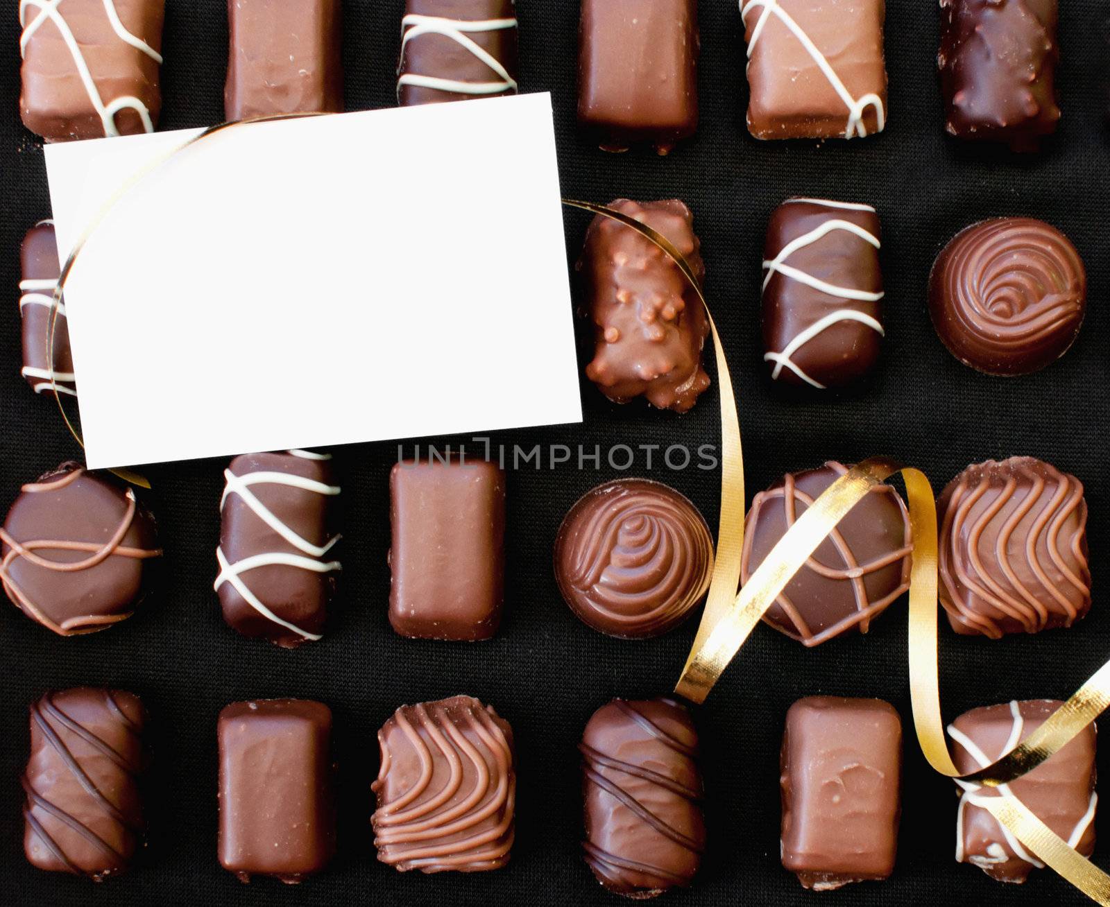 Chocolates with decorative gold ribbon and blank card 