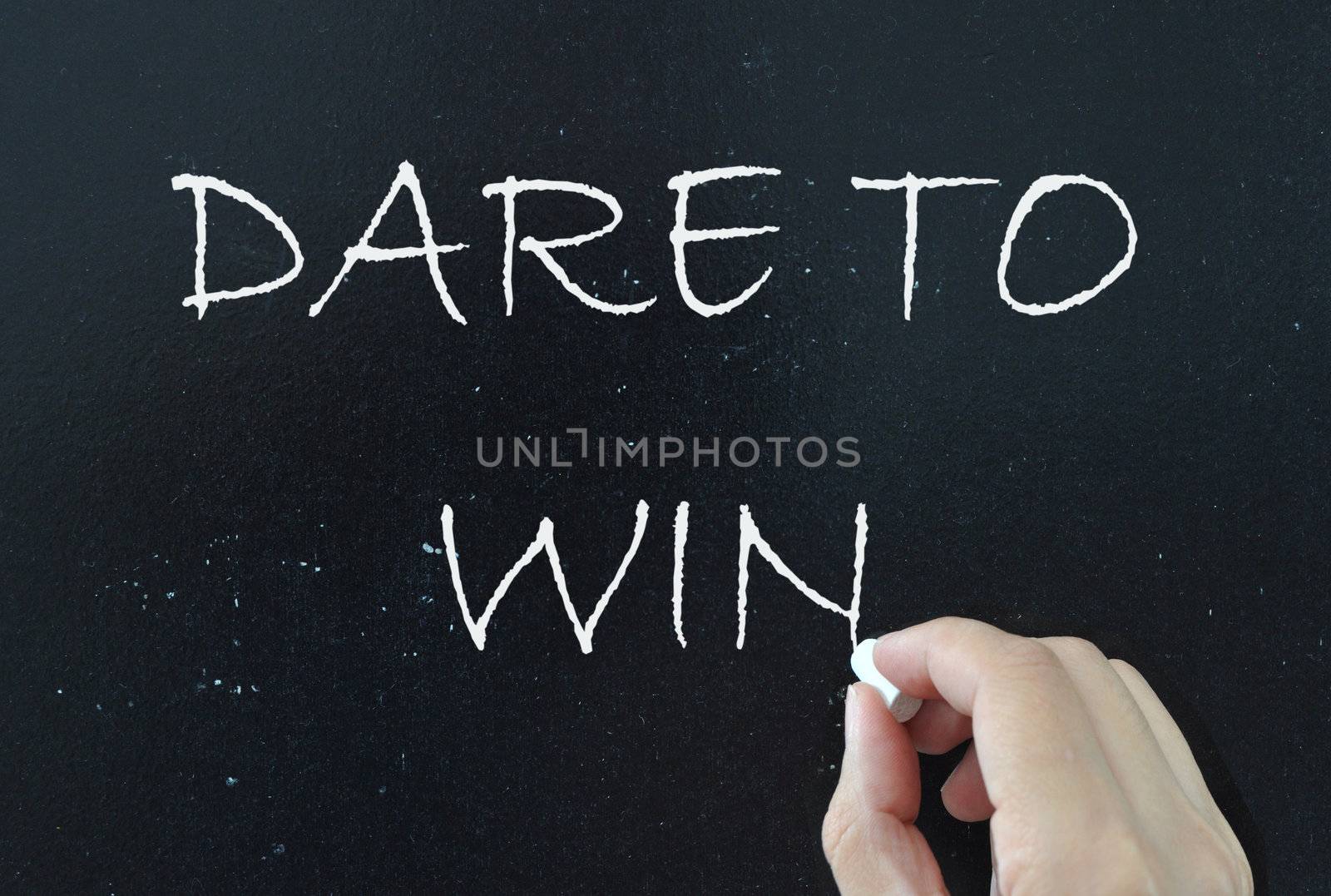 Dare to win written with chalk on a blackboard