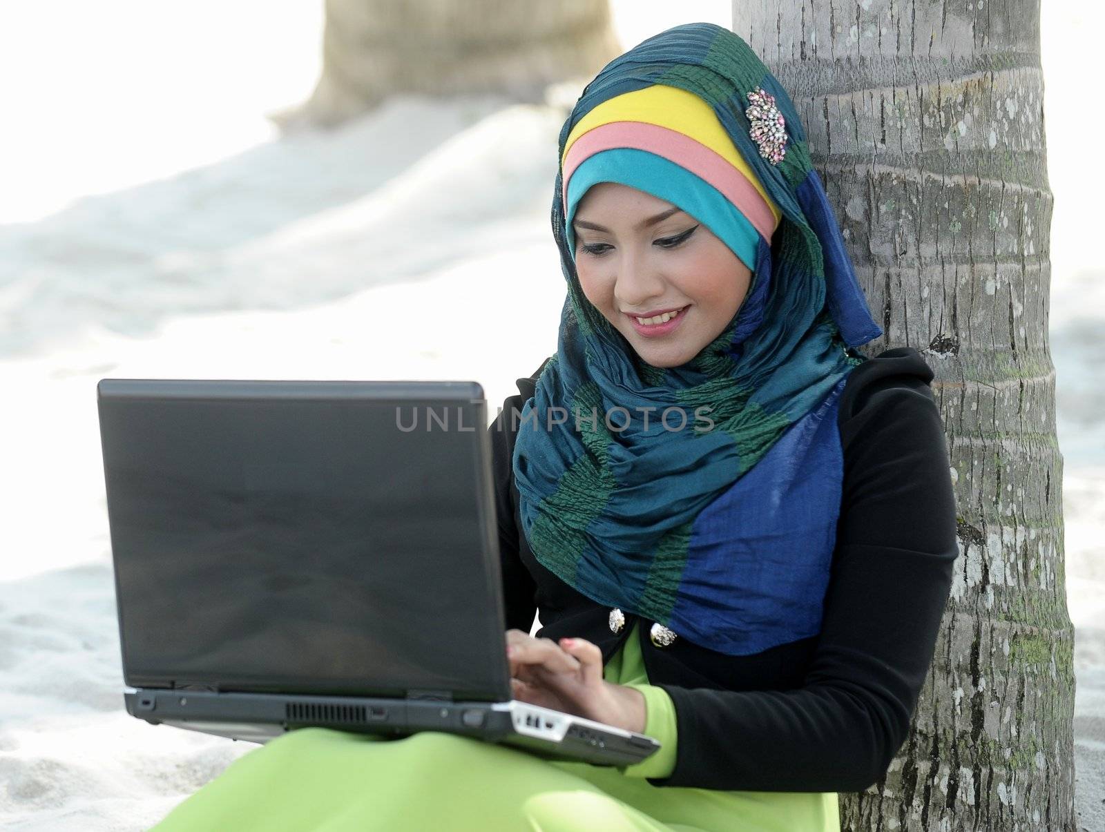 Scarf girl use laptop in beach