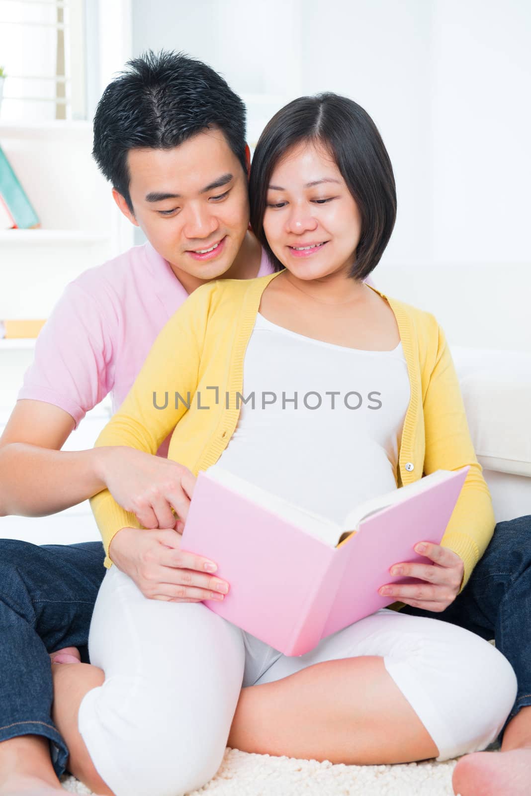Asian pregnant couple reading book  by szefei