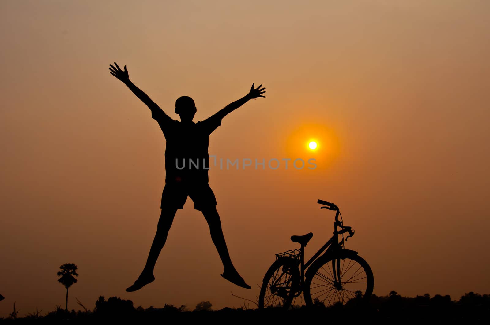 silhouette of boy happy with bicycle