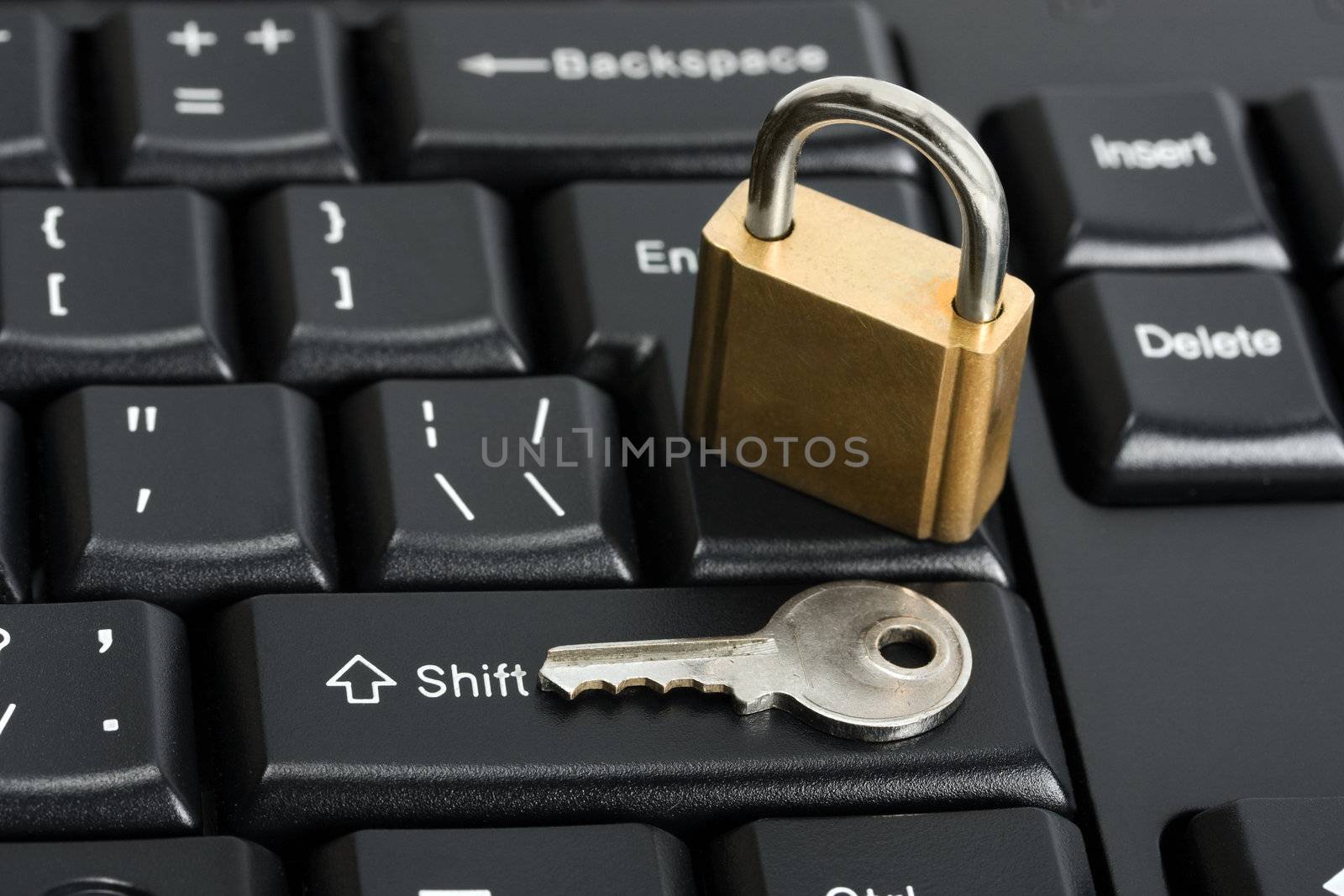 Padlock on the computer keyboard. Safety concept with key
