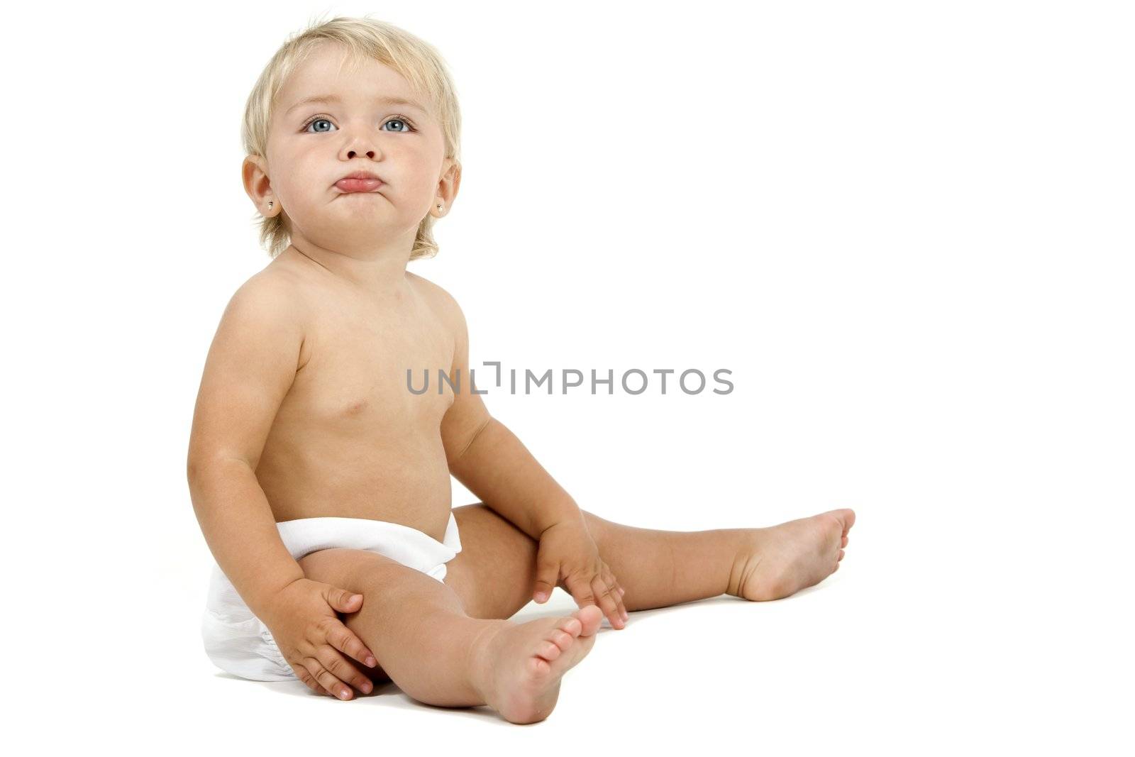 Blue eyed baby girl in huggies with no care face expression. Isolated on white background.